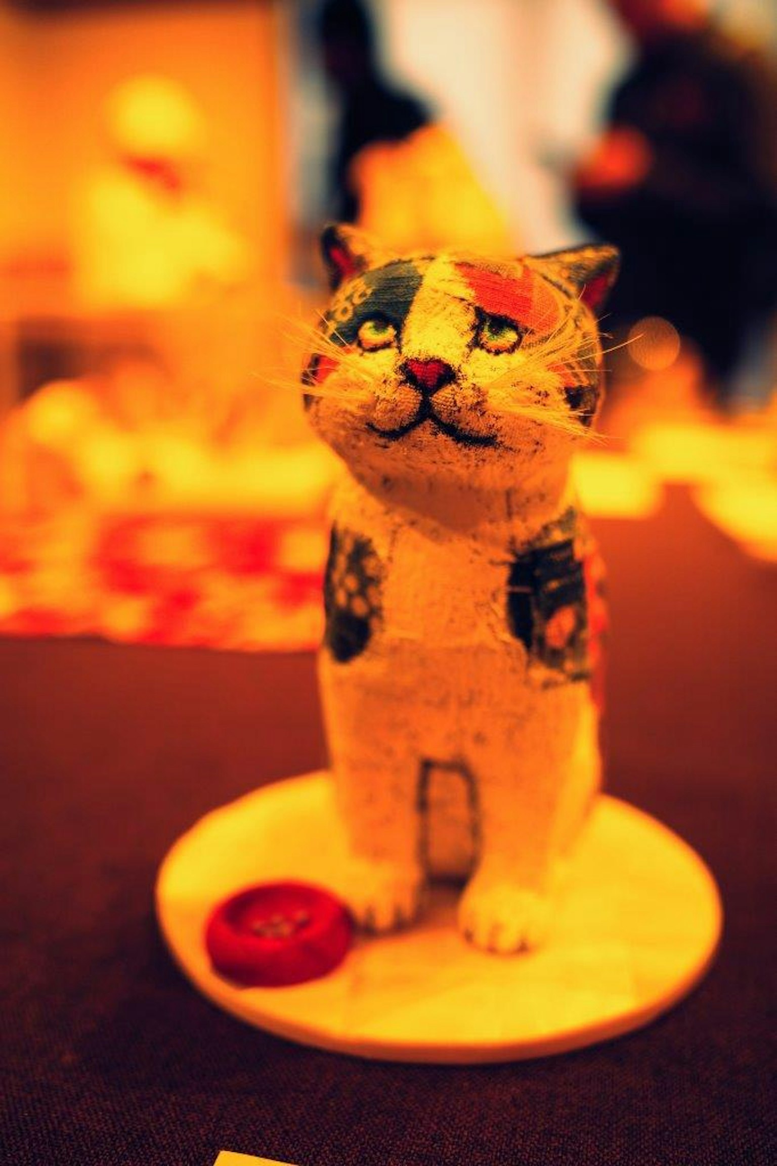Colorful patterned cat sculpture standing on a base