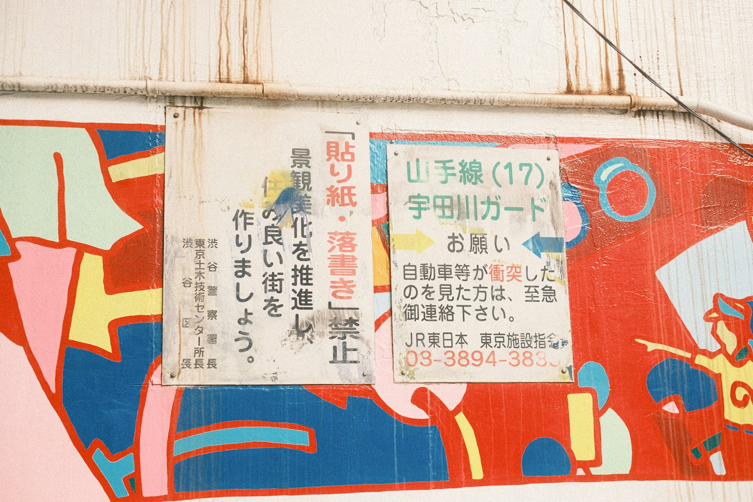 Une murale colorée avec un panneau en japonais discutant du développement communautaire et de la prévention du vandalisme