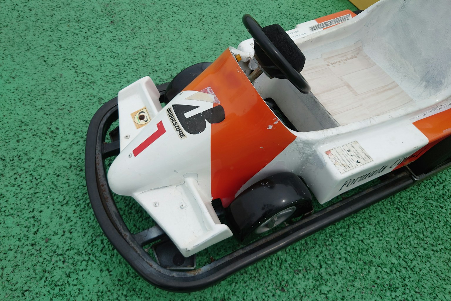 Go-kart giocattolo con design rosso e bianco e un volante