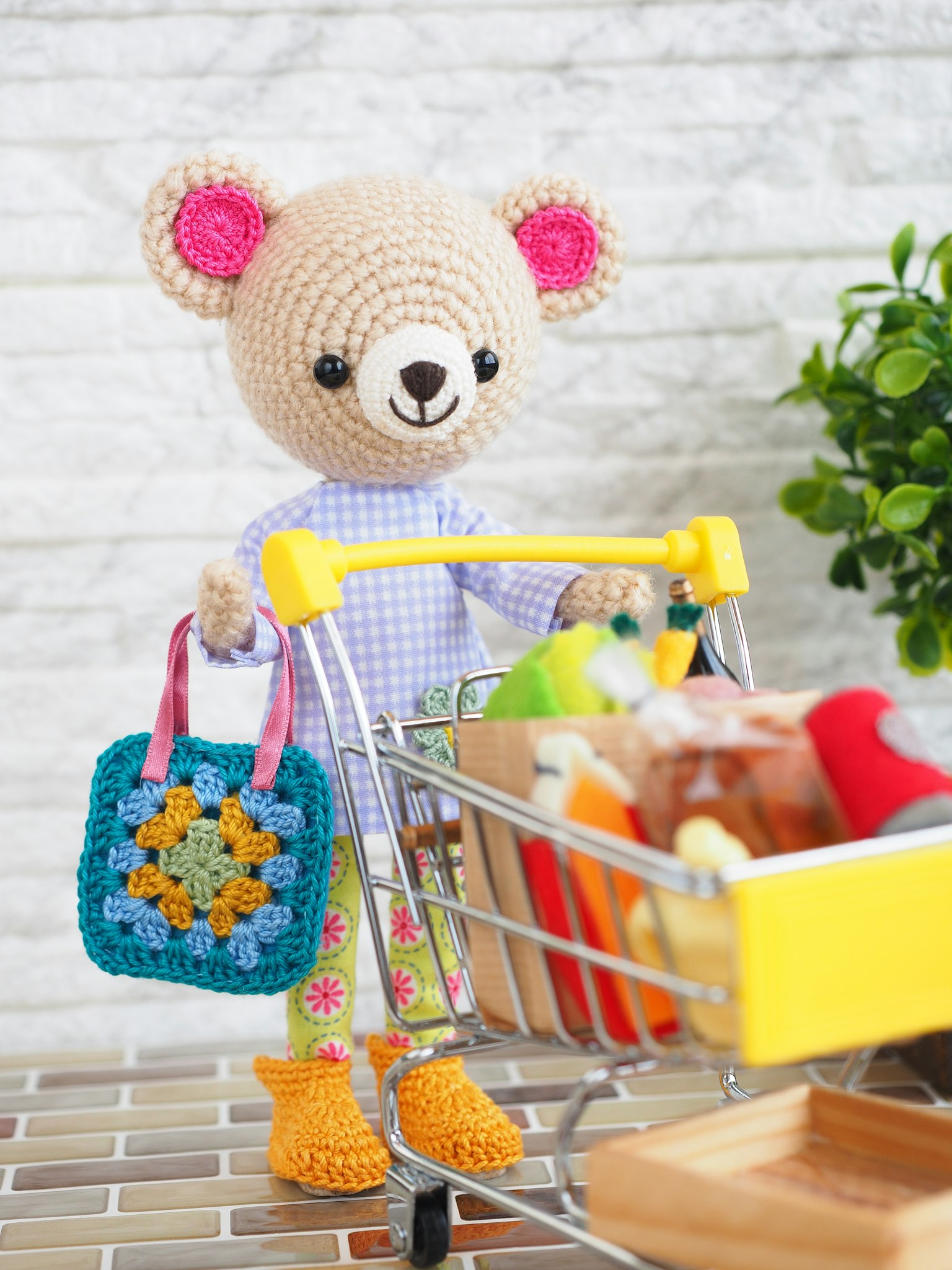 Một con gấu bông dễ thương cầm giỏ đi chợ đầy màu sắc và xe đẩy chứa đầy thực phẩm sống động