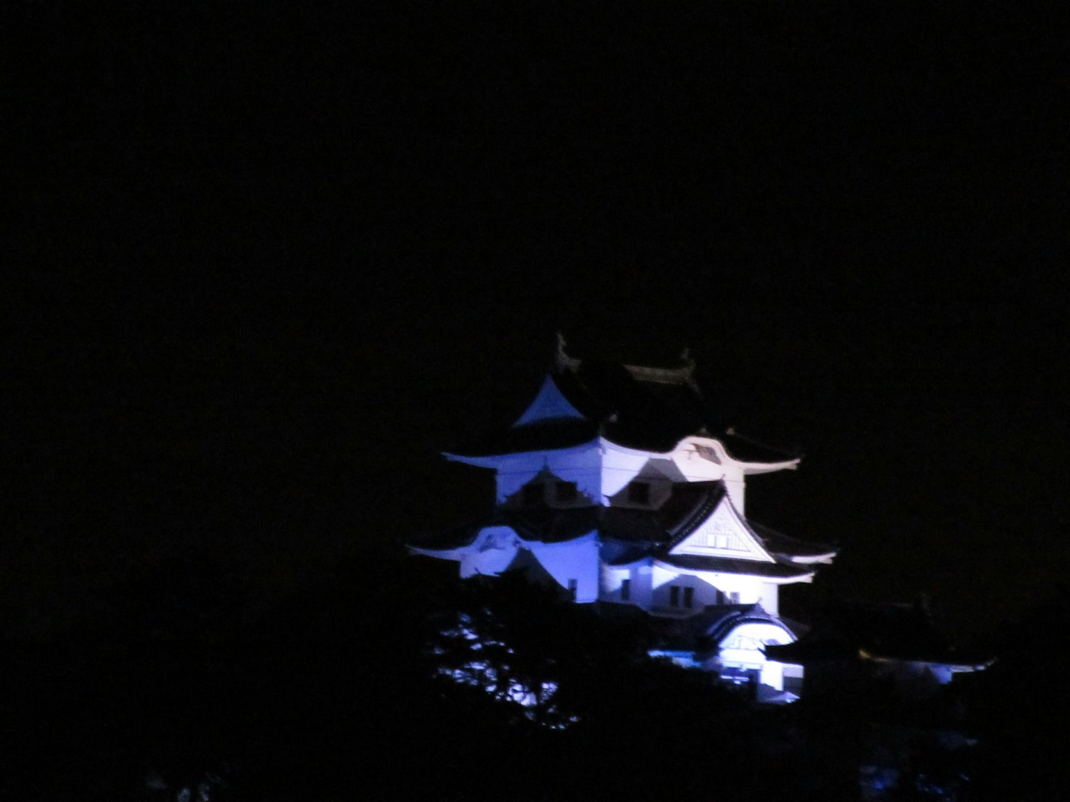 夜晚藍色燈光照亮的日本城堡輪廓