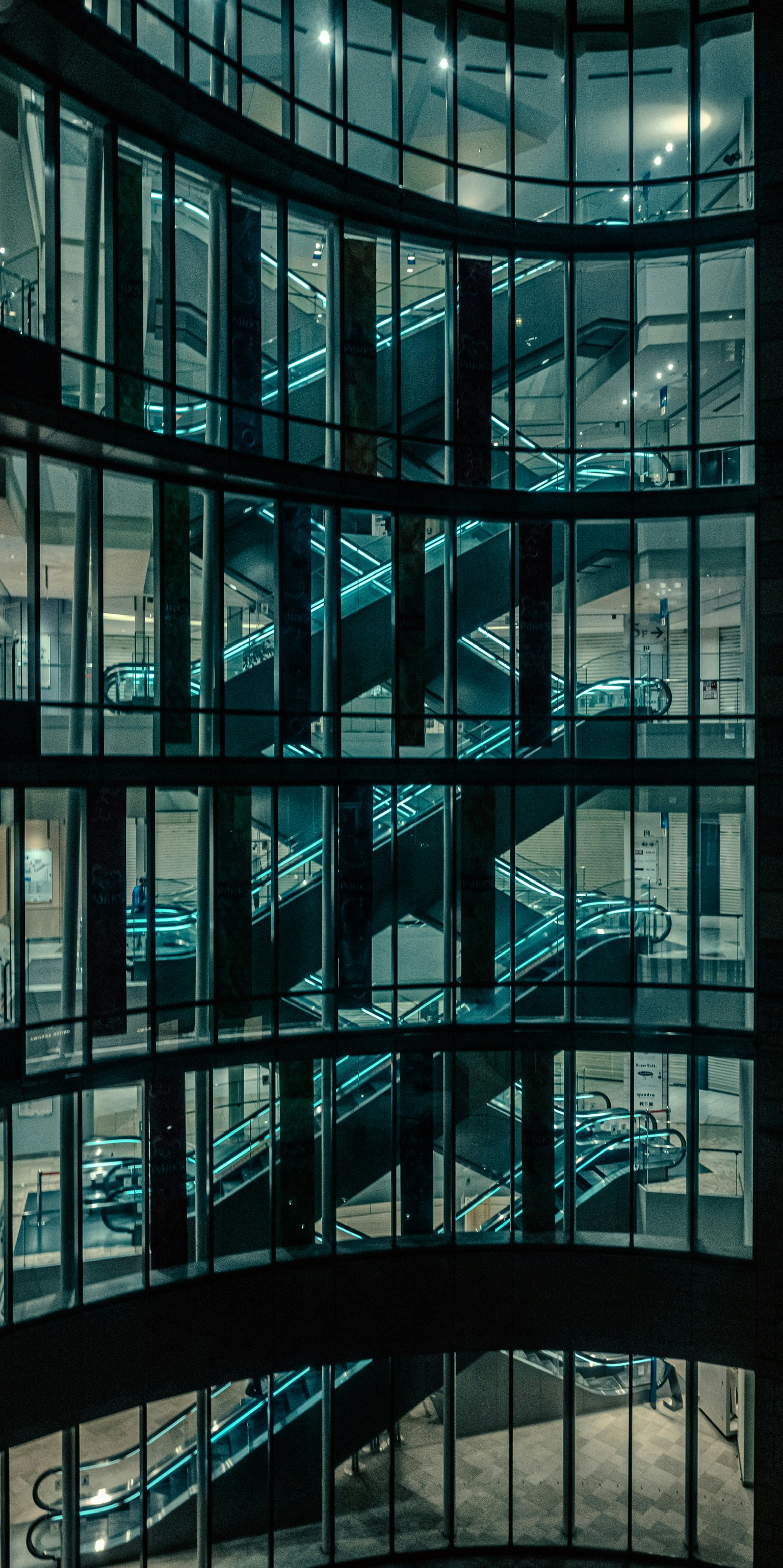 Interior of a modern building featuring a spiral staircase surrounded by glass walls