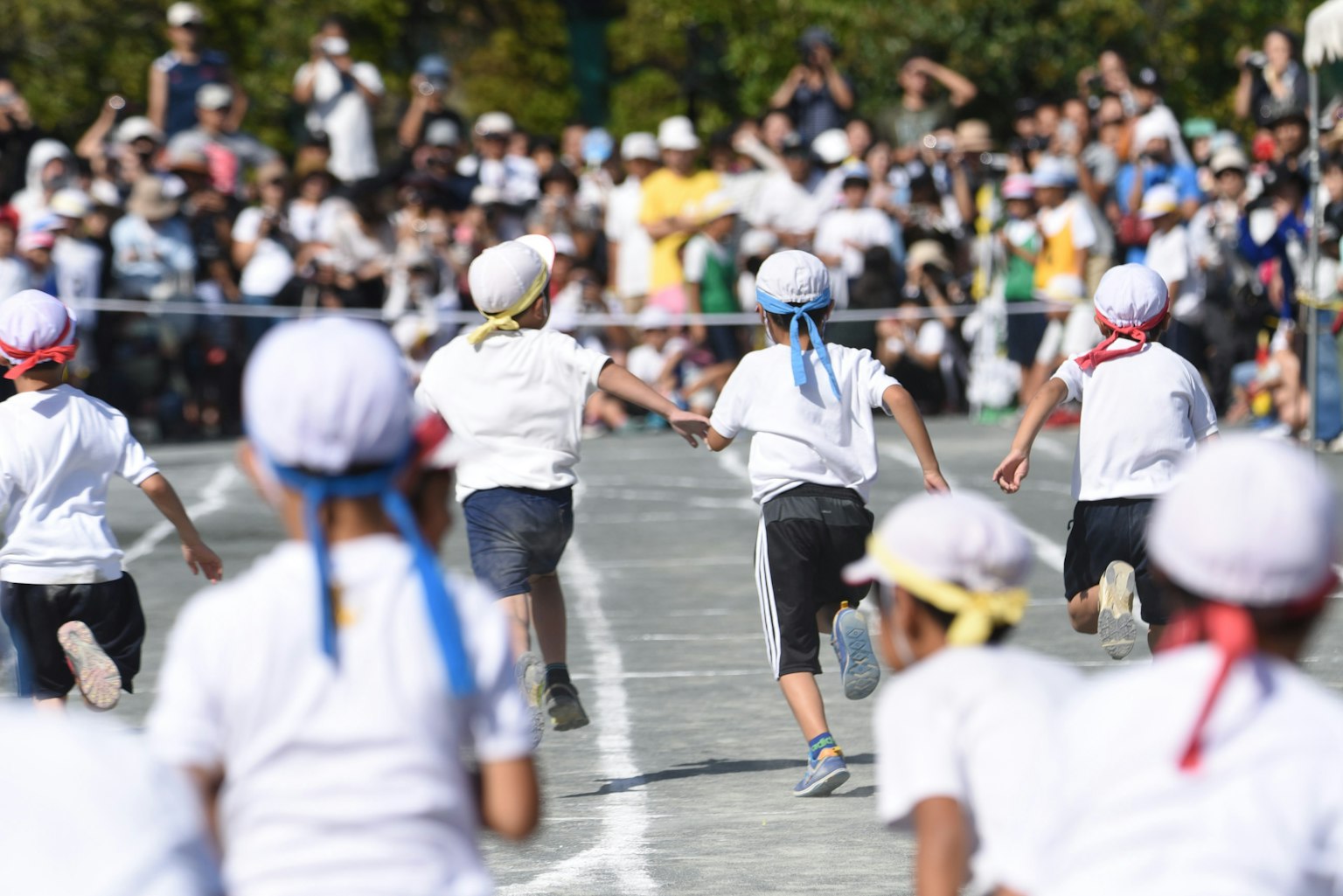 Niños corriendo durante un evento deportivo con espectadores