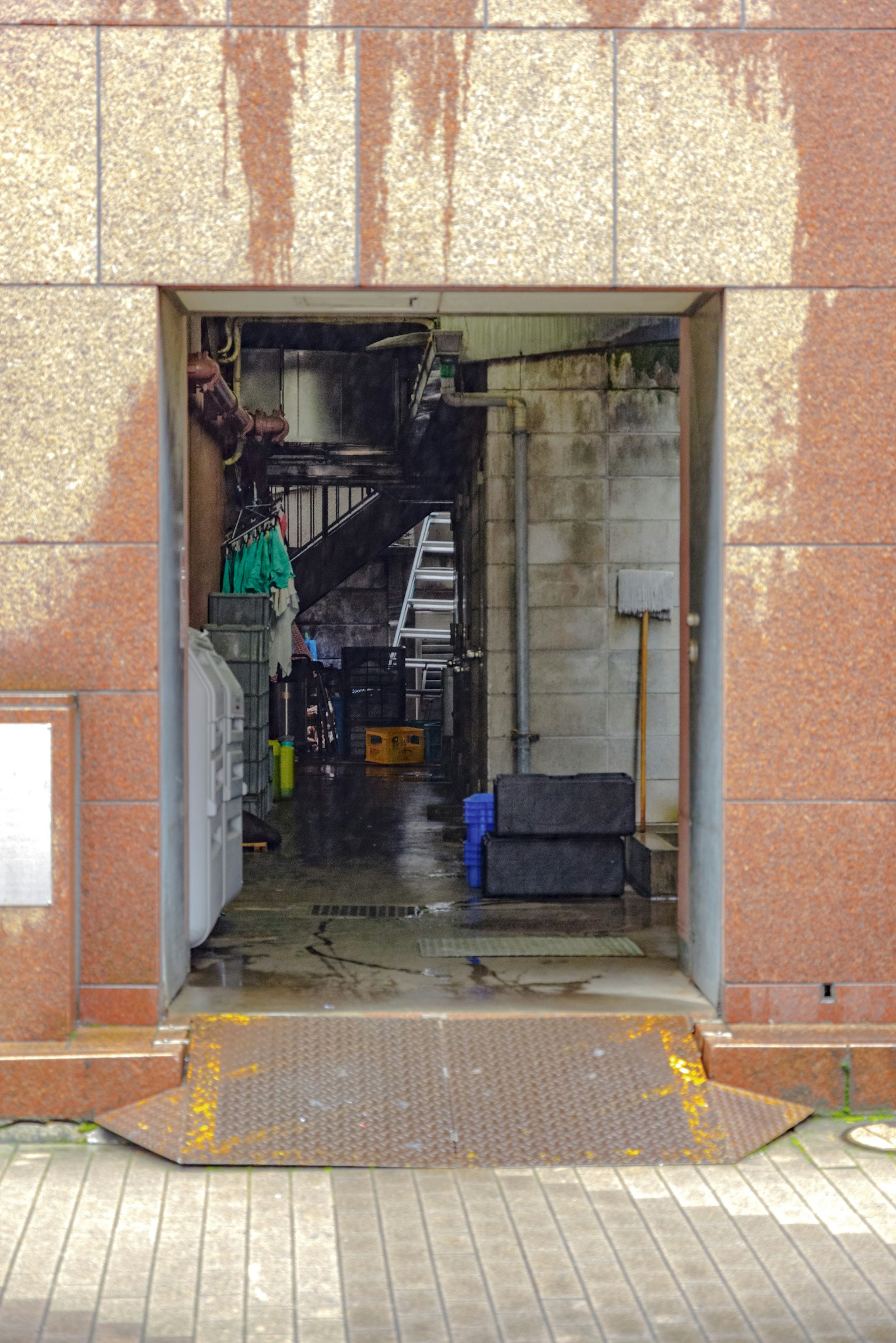 View of a dark corridor and staircase from a building's back entrance