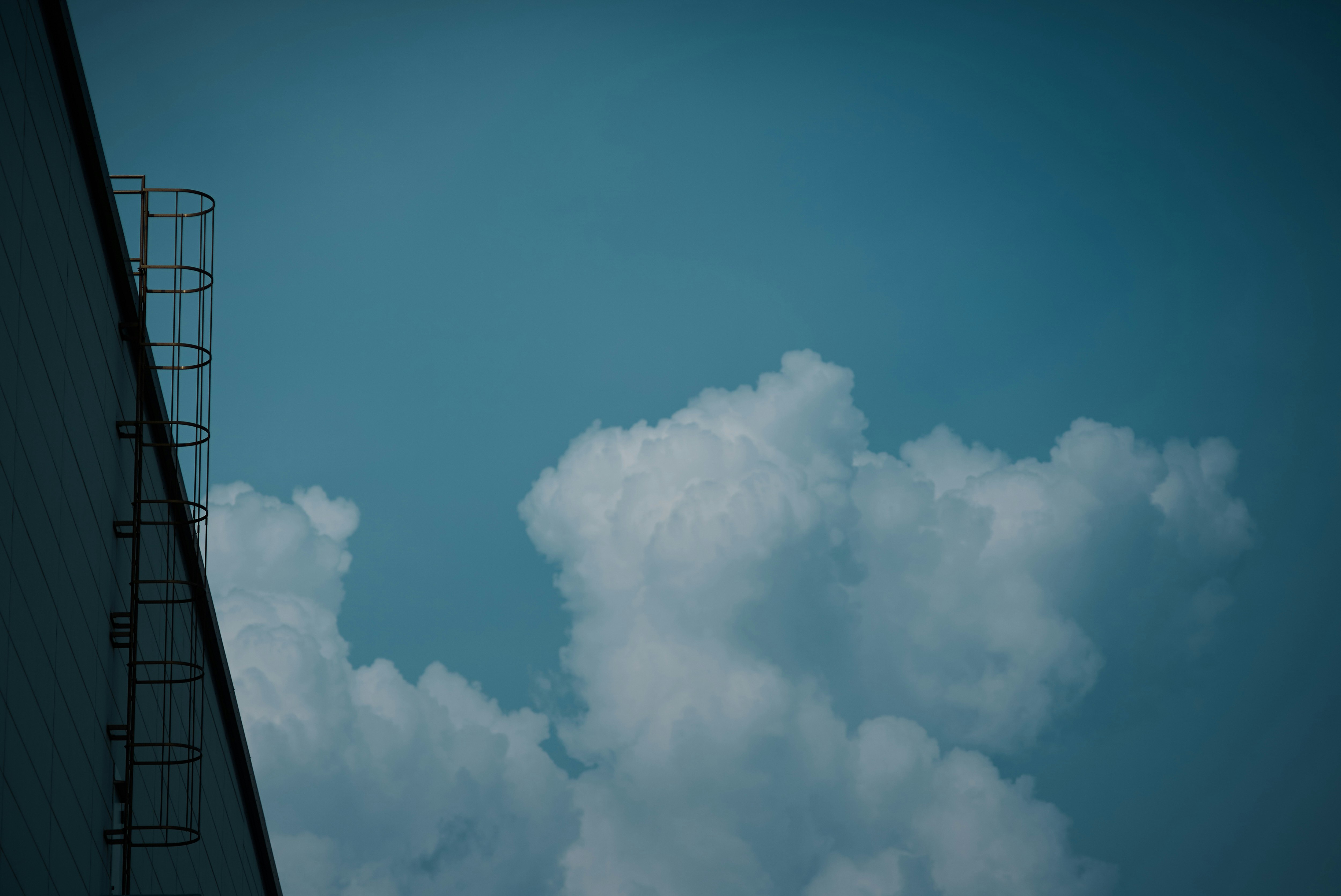 blue sky with billowing clouds and part of a building