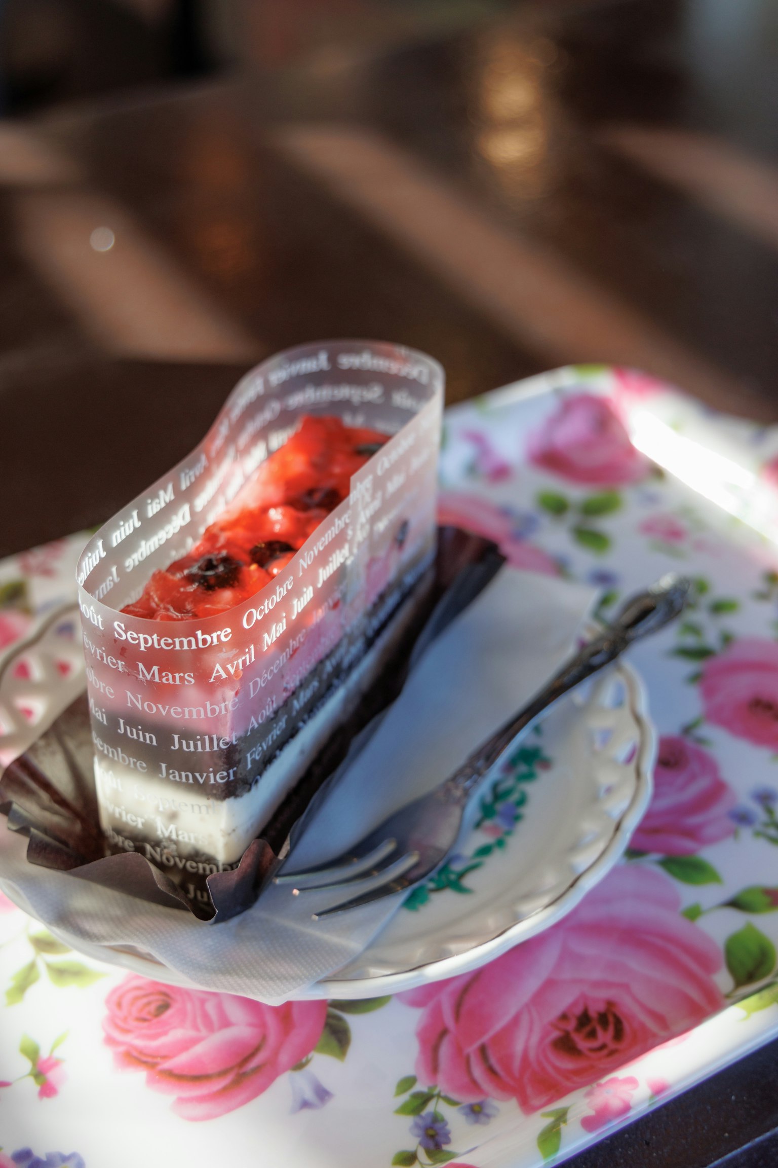 Ein Stück Dessert auf einem blumendekorierten Tablett mit einer Gabel