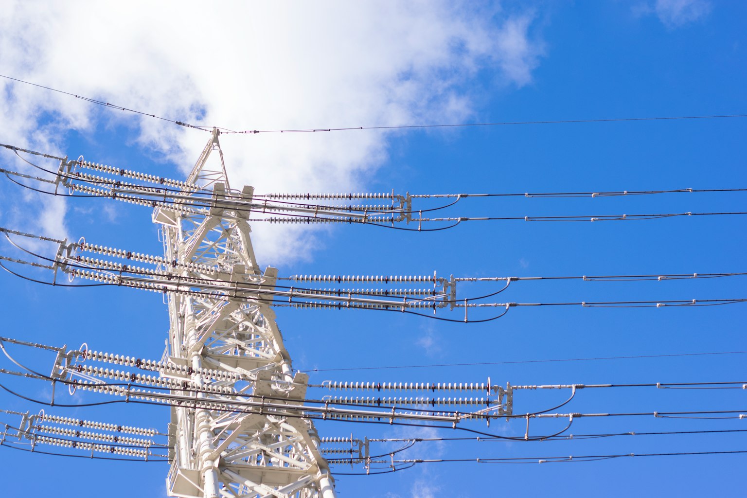 Vista dettagliata di un palo elettrico e fili contro un cielo blu