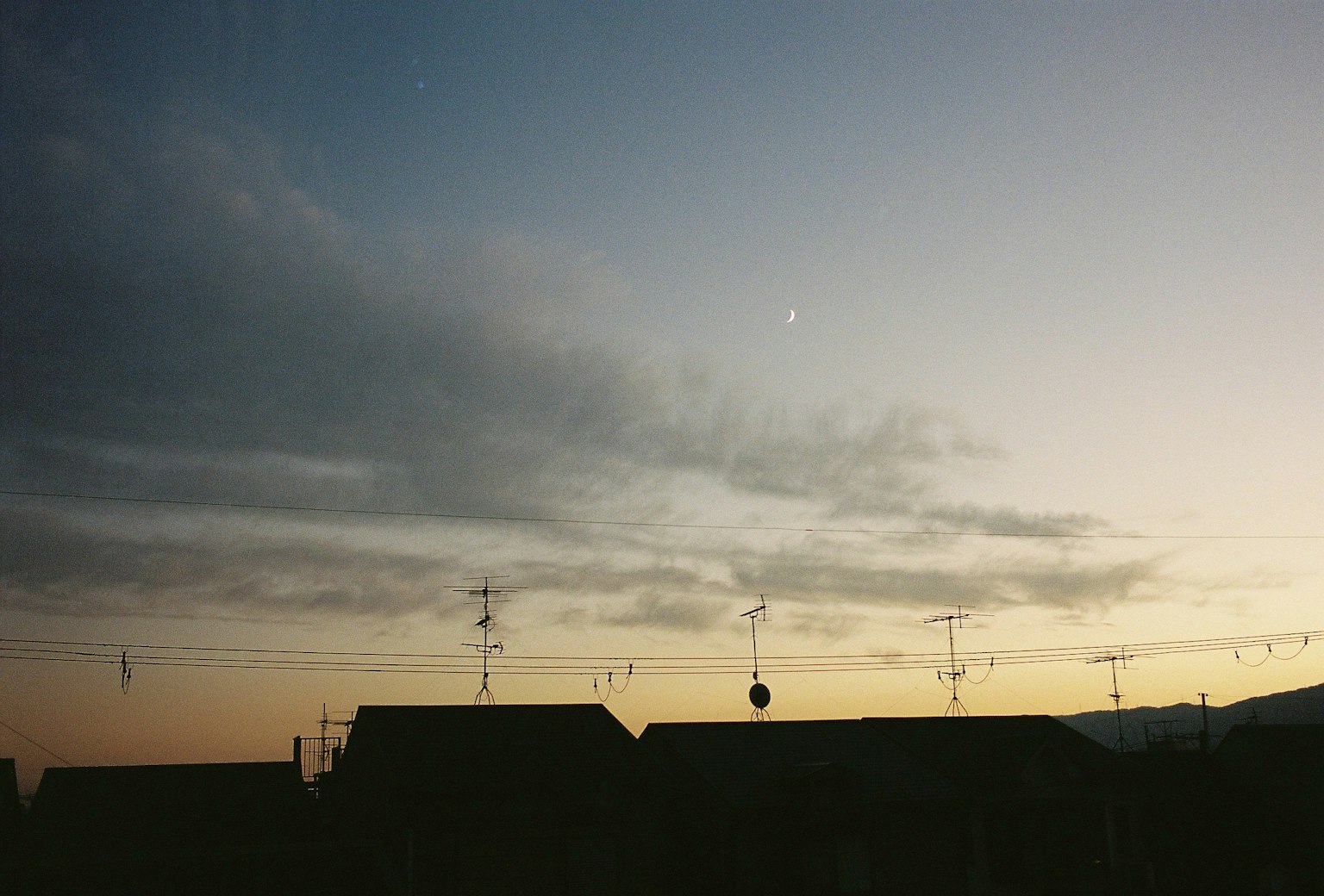 Silhouette of houses against a colorful sunset sky
