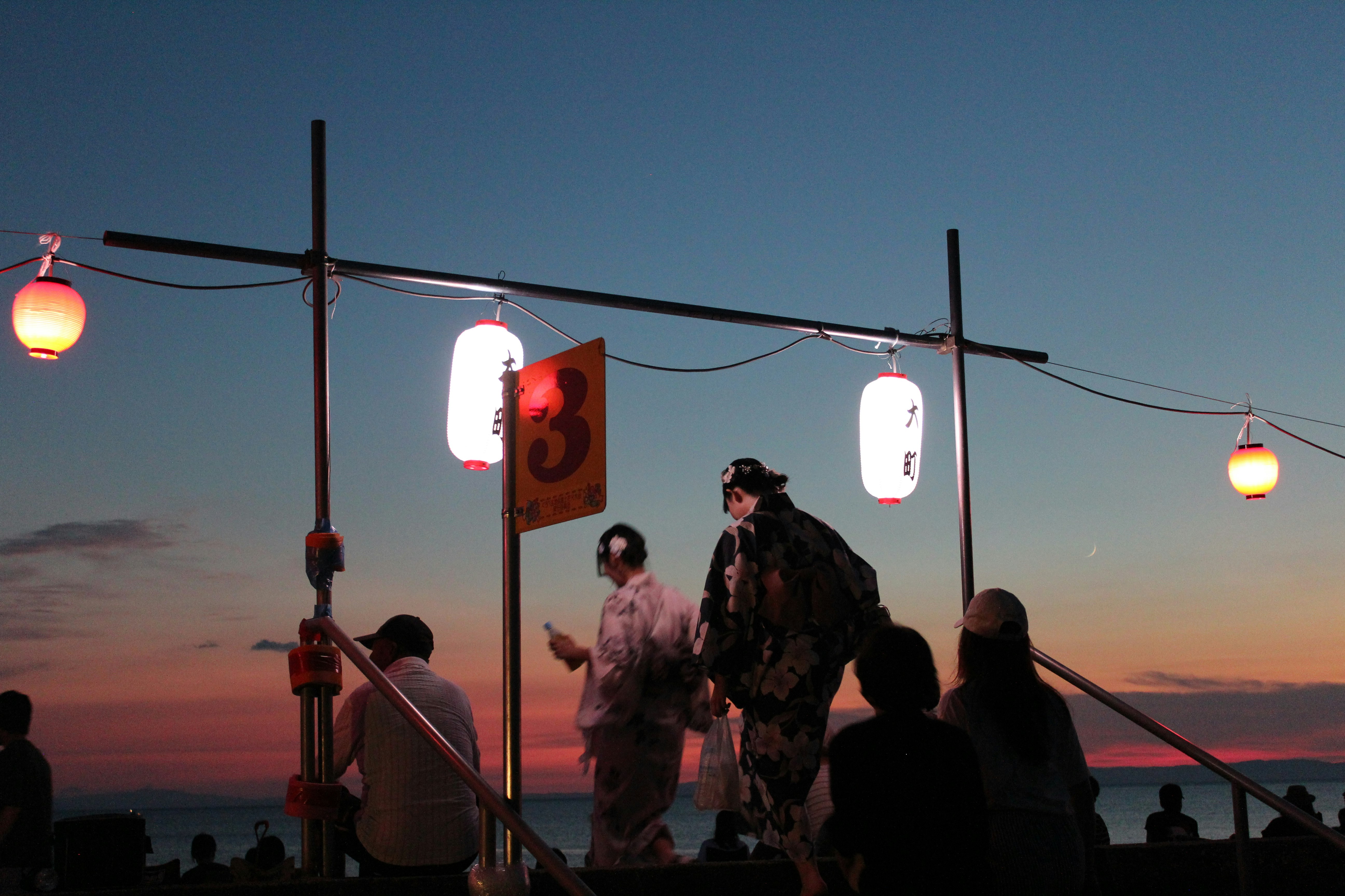 festival di fuochi d’artificio sulla costa al tramonto con lanterne