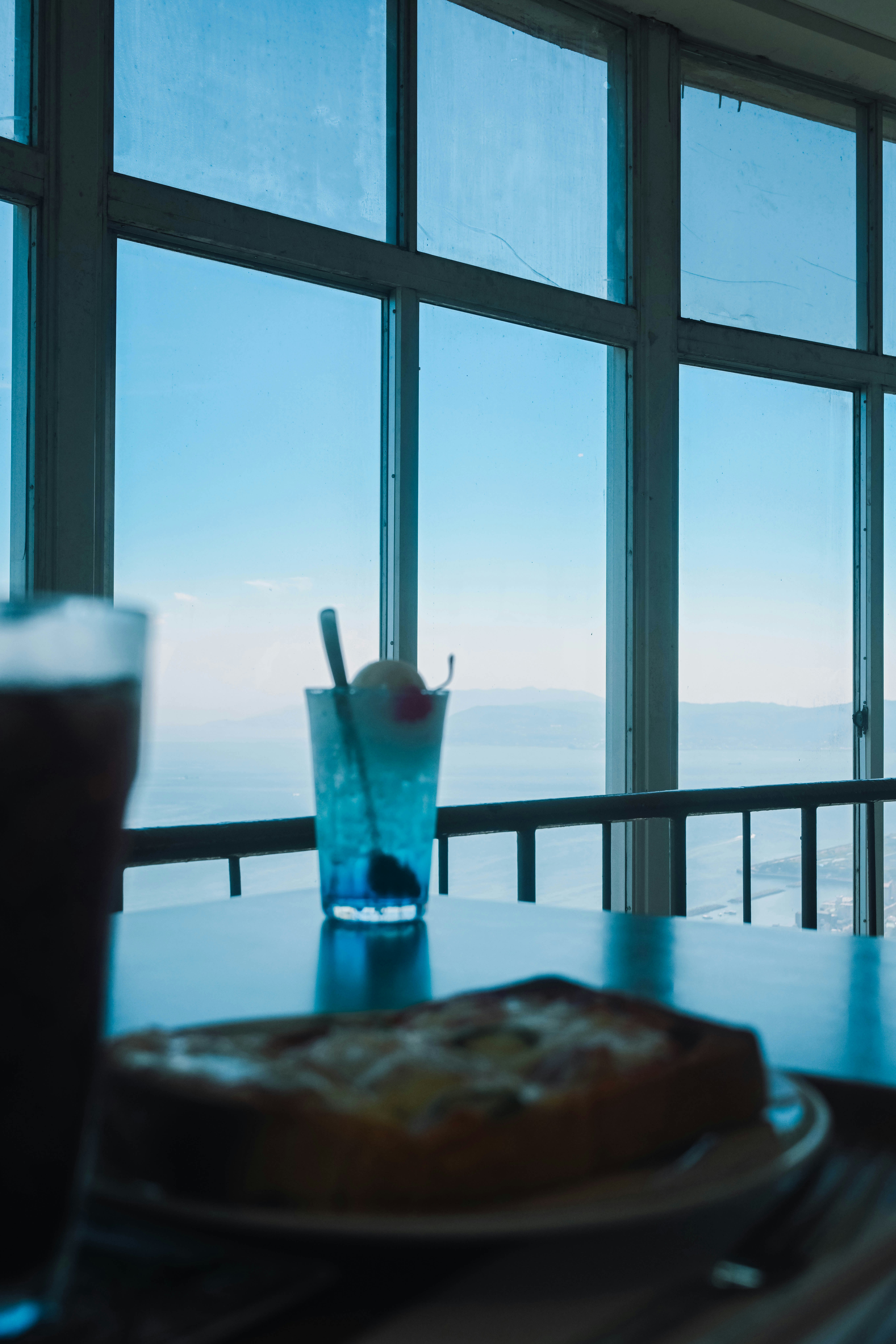 海を望む窓辺のカフェテーブルとドリンク
