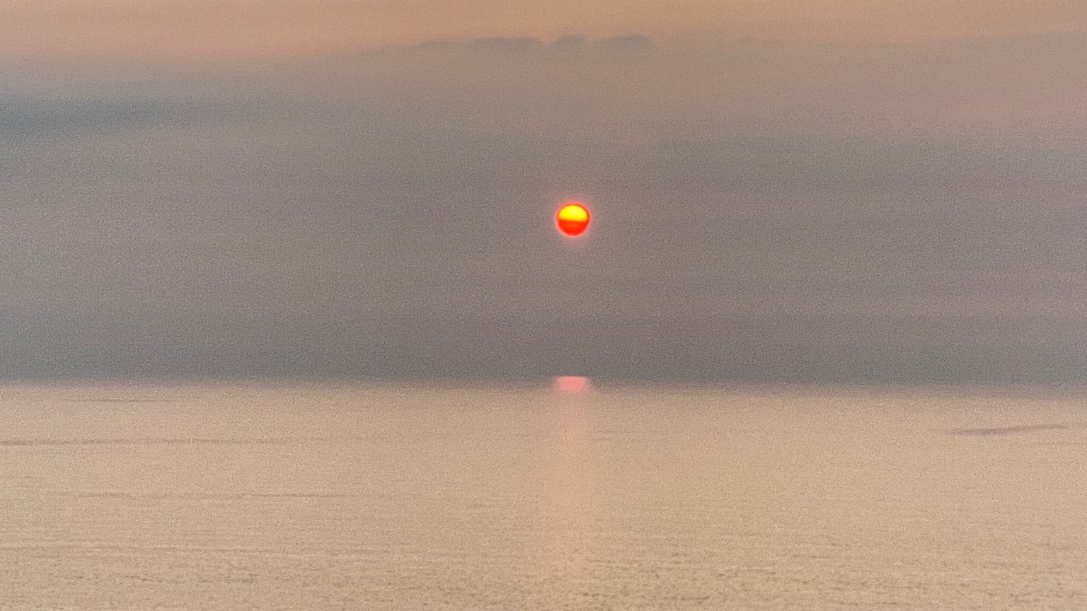 Atardecer sobre el océano con una superficie de agua tranquila