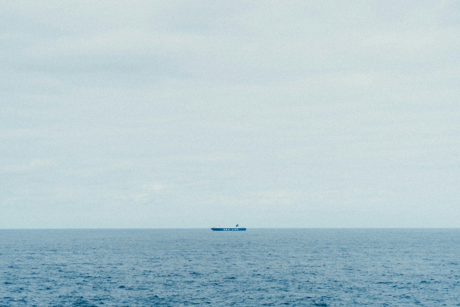 Un navire sur une mer calme sous un ciel nuageux