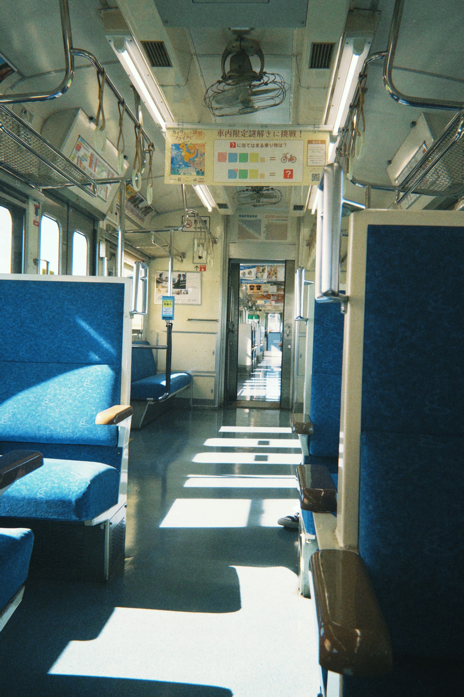 Interior view of a train carriage with blue seats