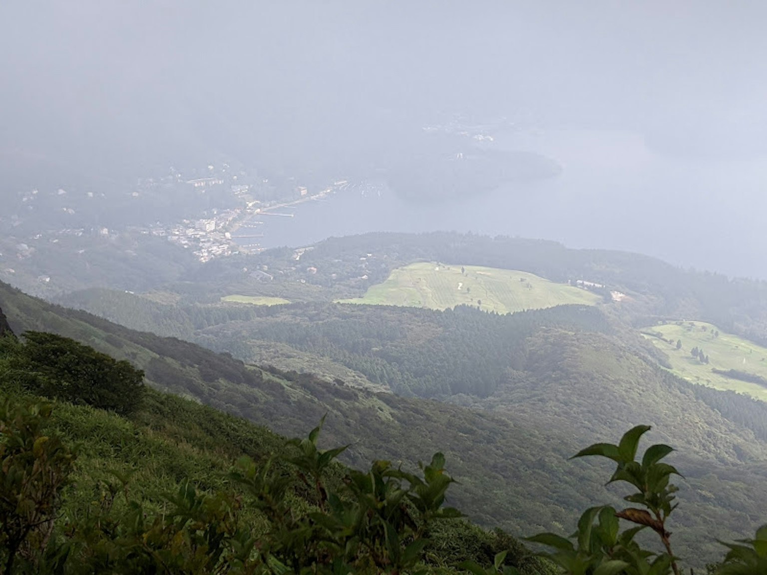 Paesaggio montano avvolto nella nebbia con una città distante