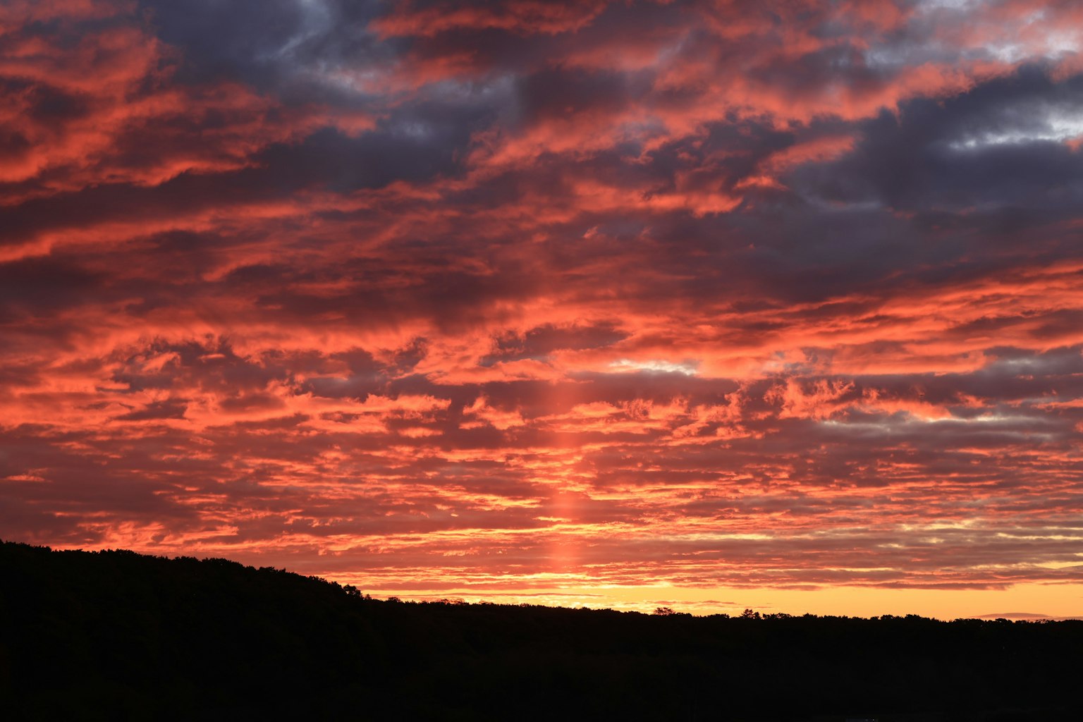 夕焼けの空に赤とオレンジの雲が広がる美しい風景