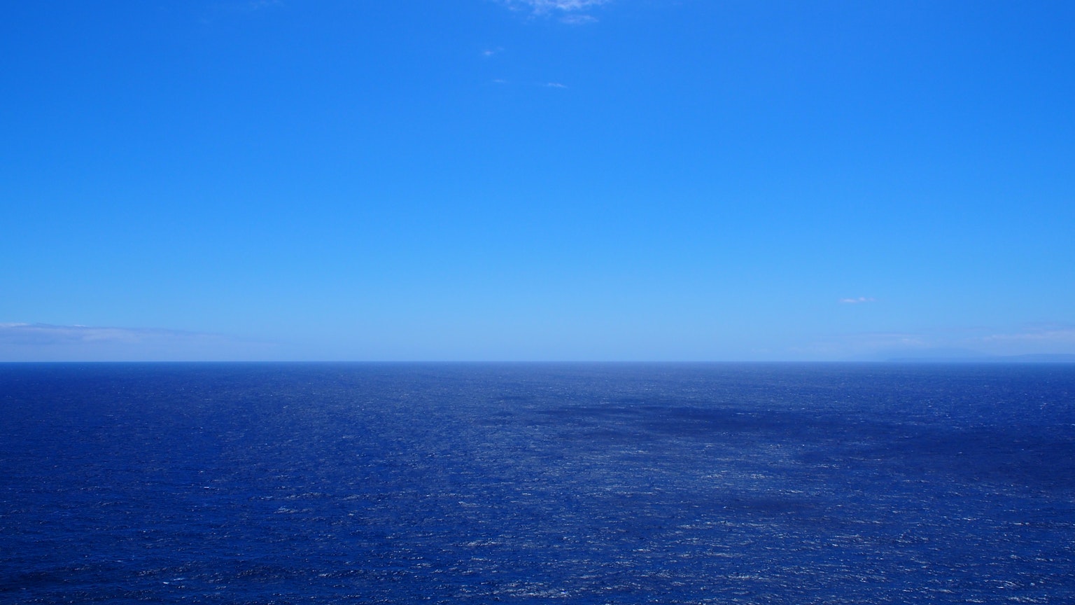 Inmenso océano azul que se encuentra con el cielo claro