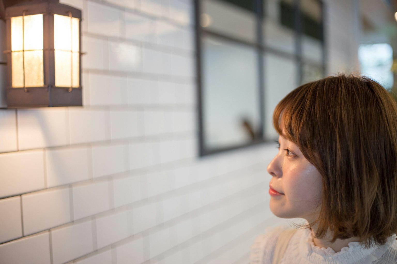 Une femme regardant une lampe murale