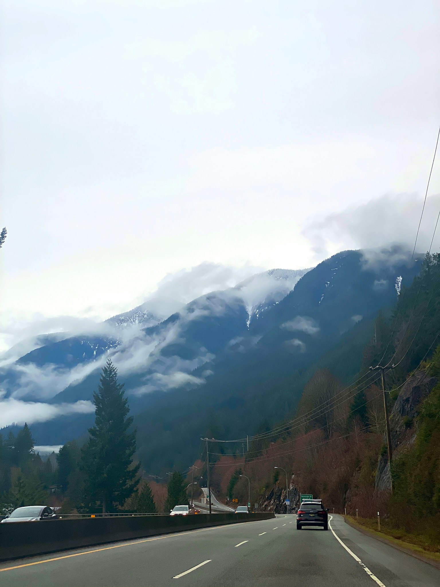 Scenic view of fog-covered mountains alongside a road