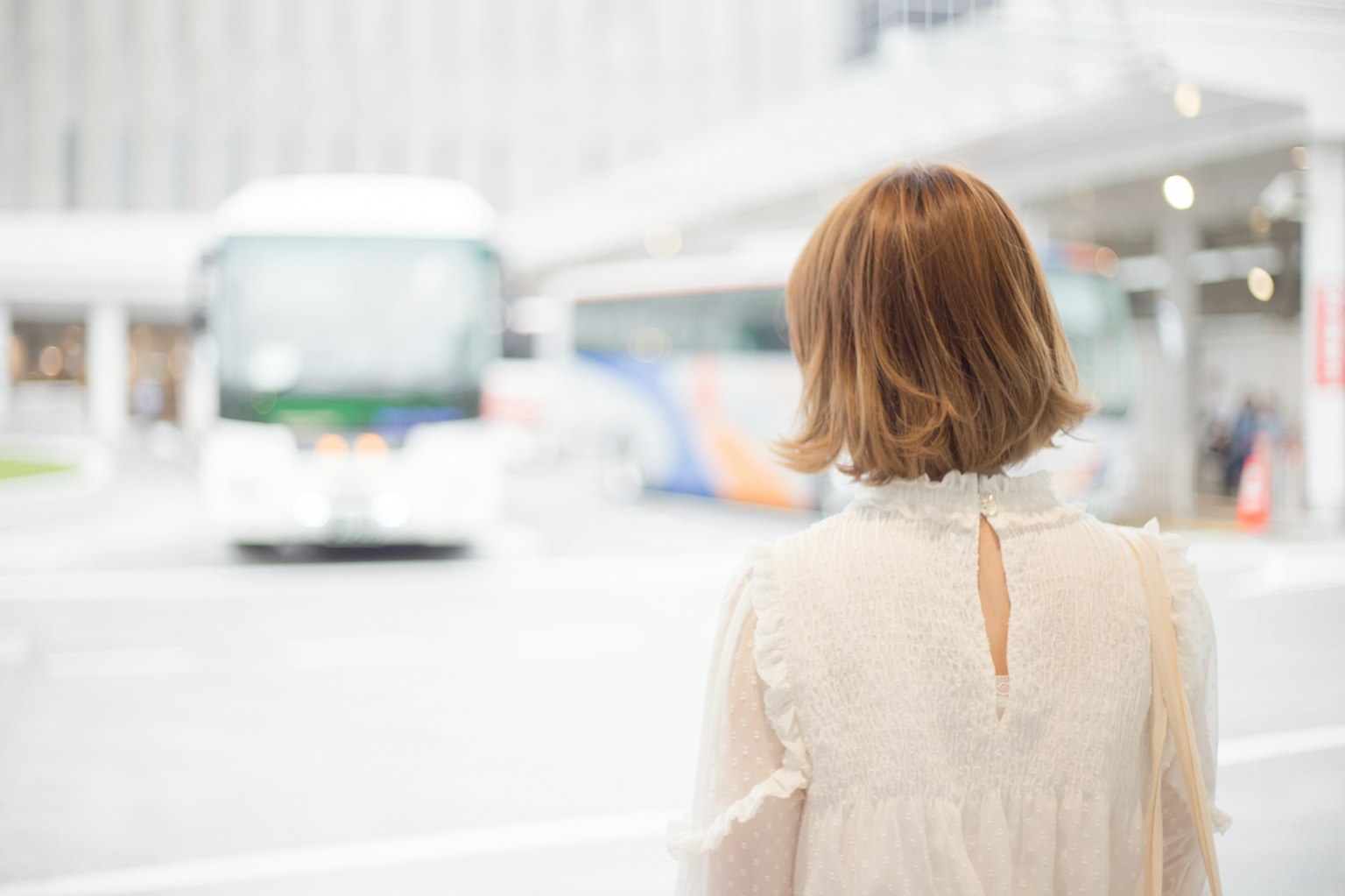 버스 정류장에서 버스를 기다리는 여성