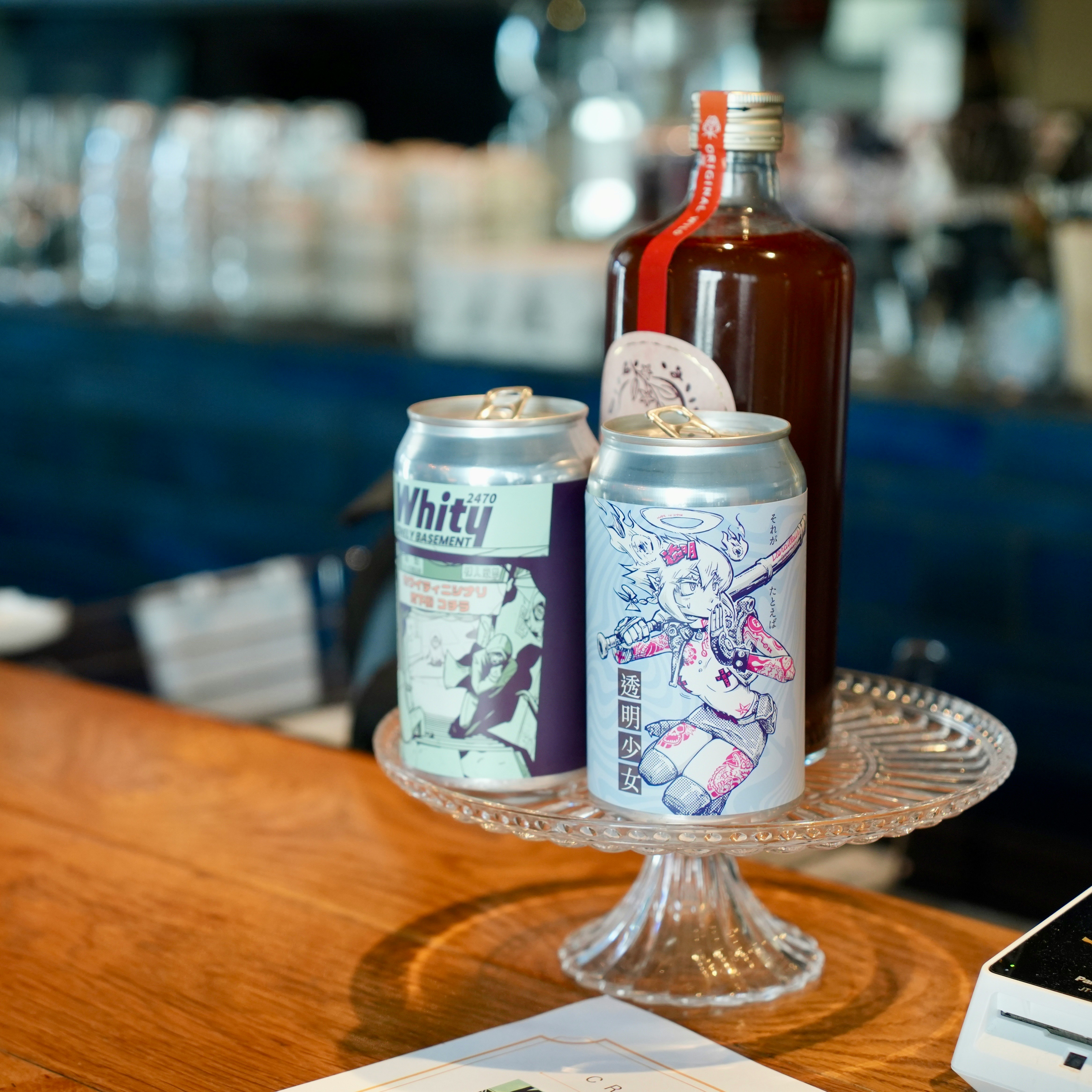 木製テーブル上の缶ビールとボトル飲料の並ぶカフェ風ディスプレイ