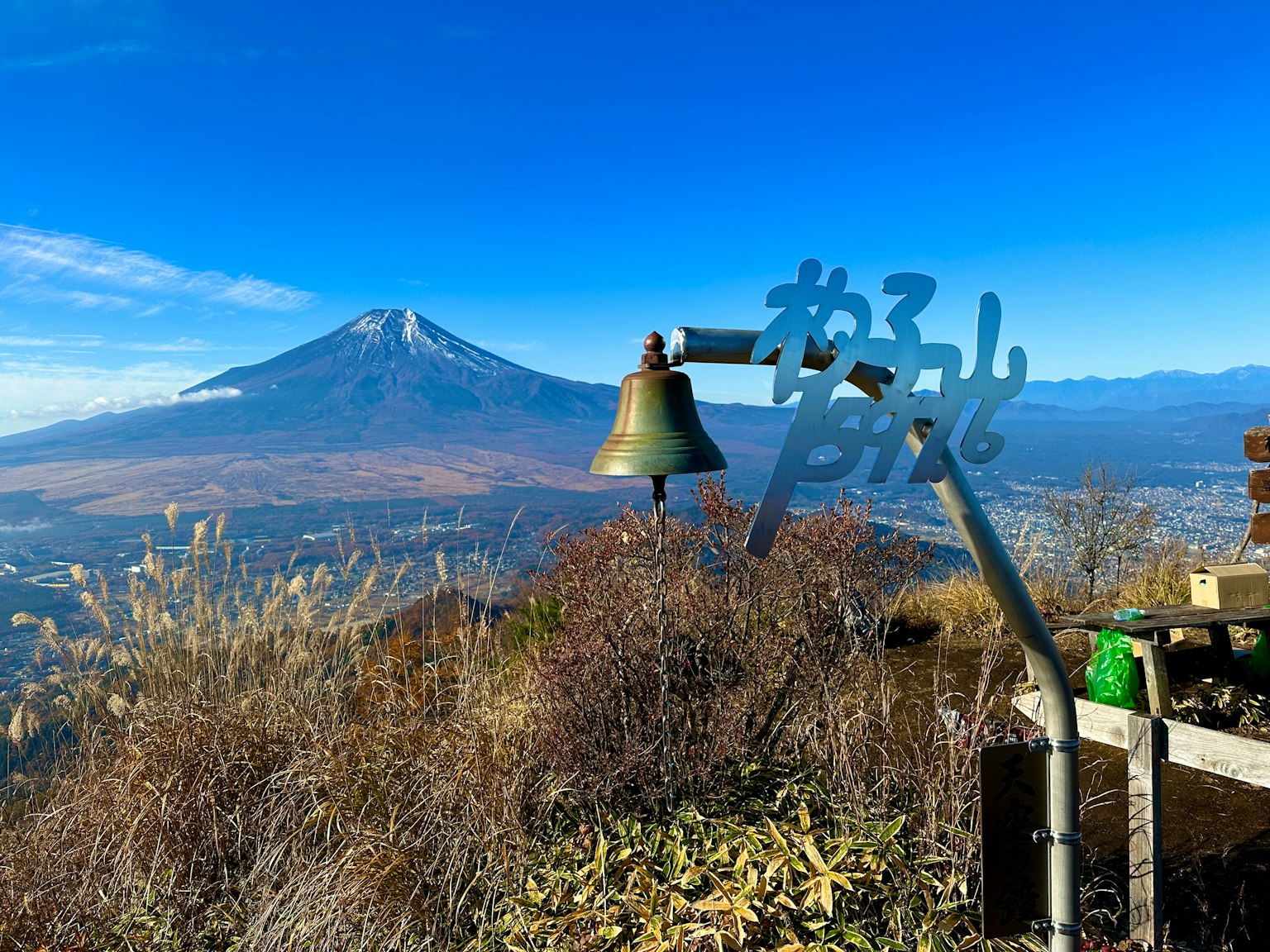 A bell and sign with Mount Fuji in the background