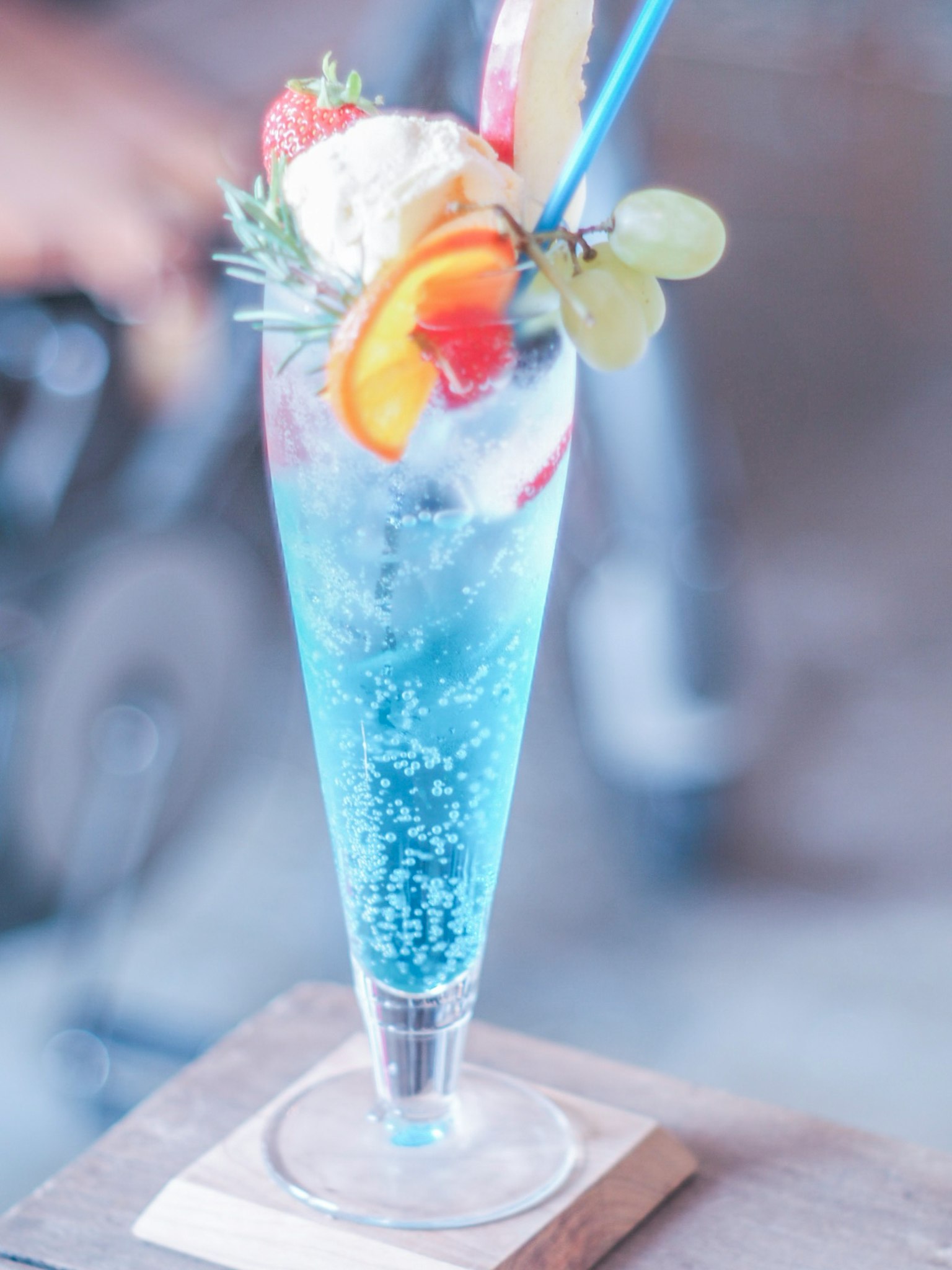 Cóctel azul decorado con frutas y helado