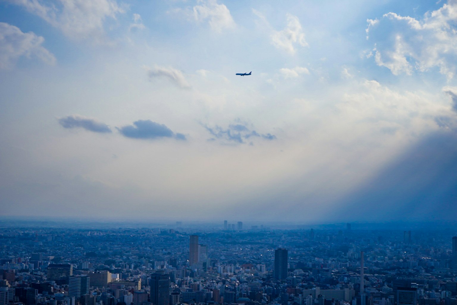 Stadtansicht unter einem blauen Himmel mit einem fliegenden Flugzeug