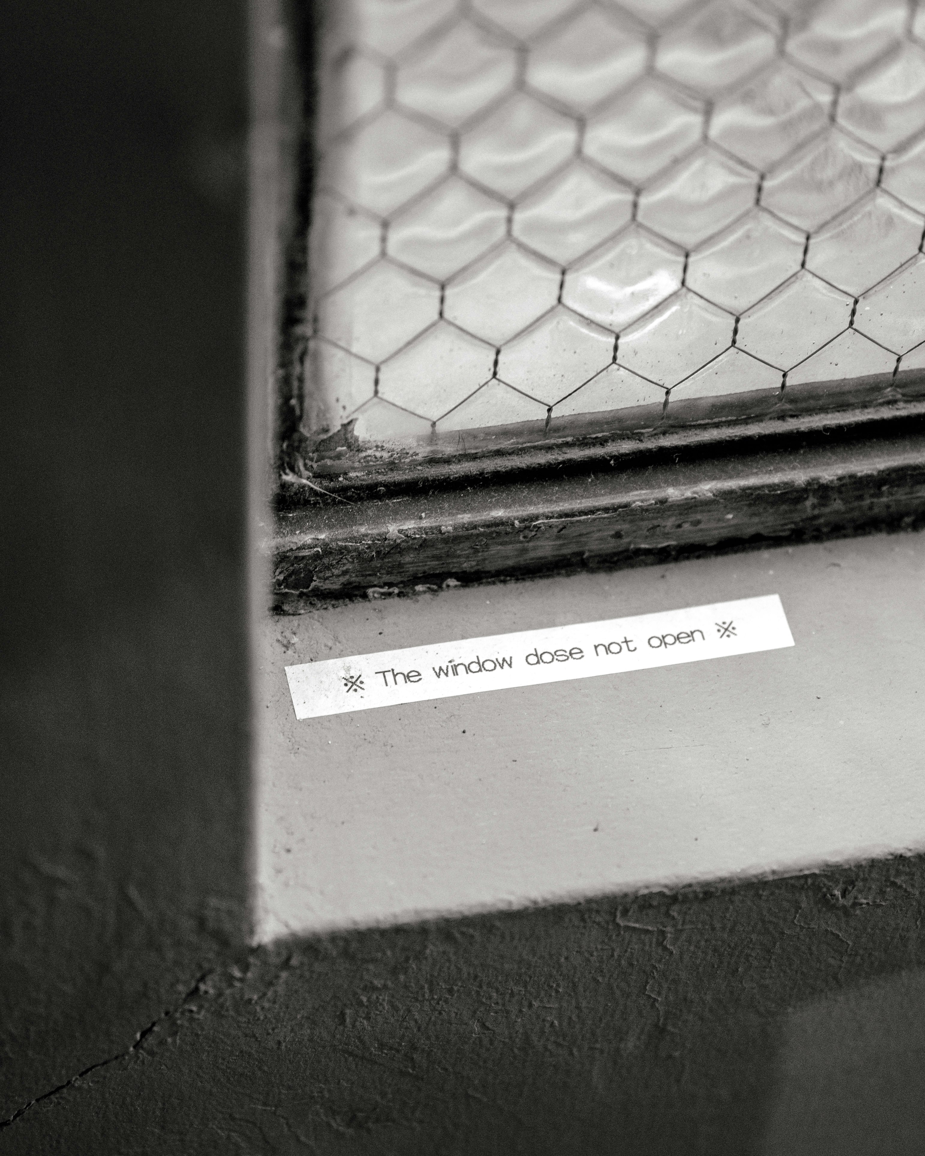 Wall with a window frame gap and a note reading “The window does not open*”