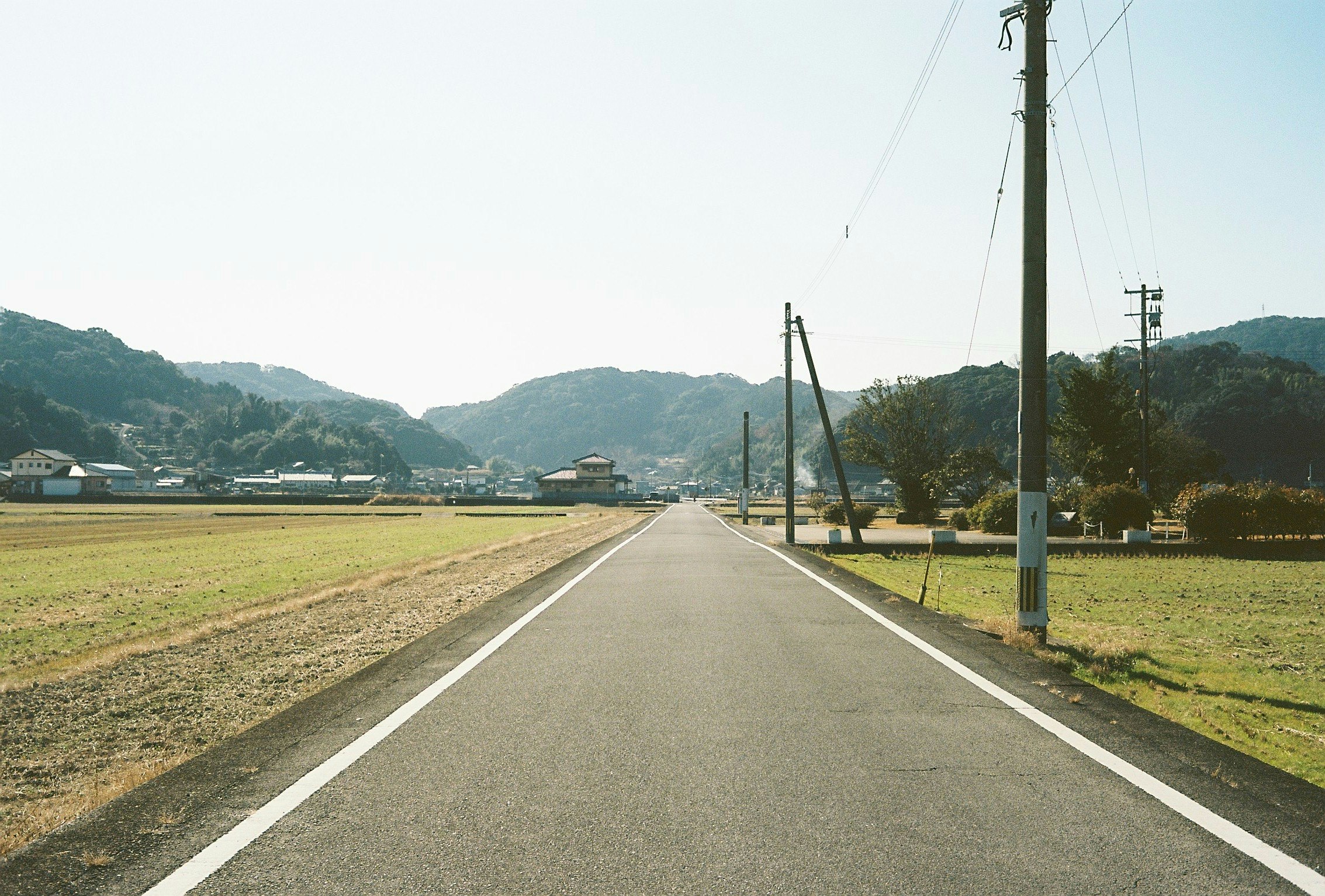 田舎の風景に続く直線道路と山々