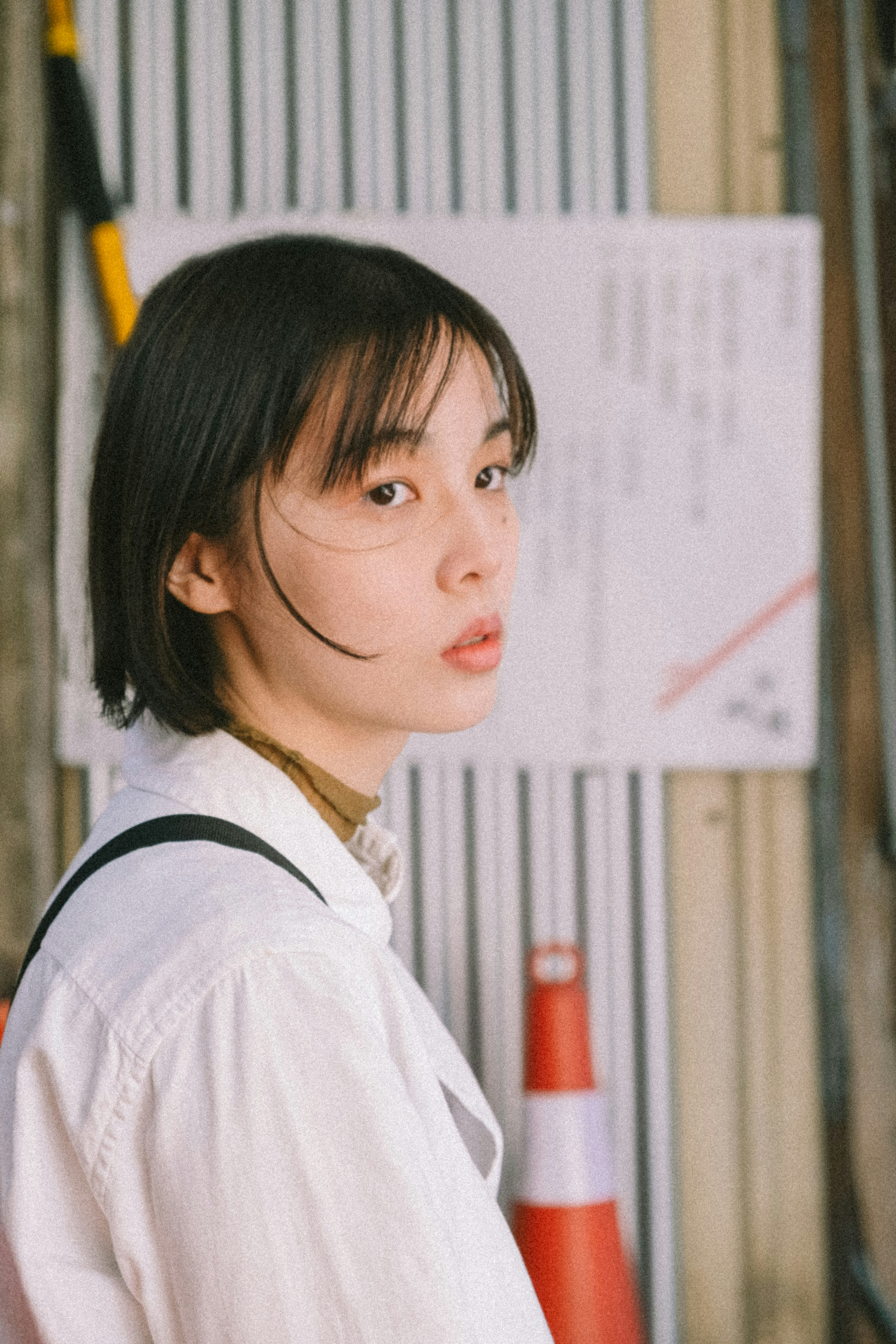 側臉的年輕女性在公告牌前回頭看