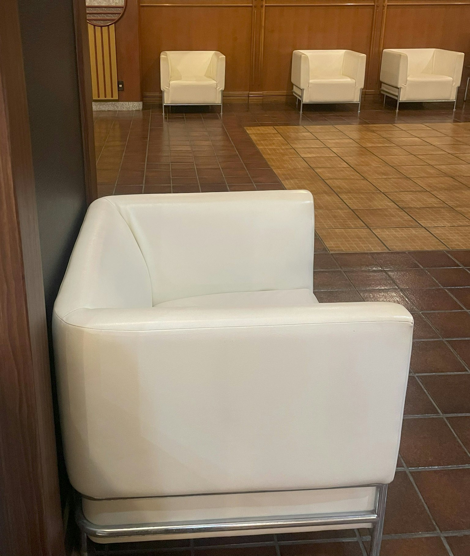 Một chiếc sofa trắng hiện đại đặt dựa vào tường trong khu vực sảnh đơn giản