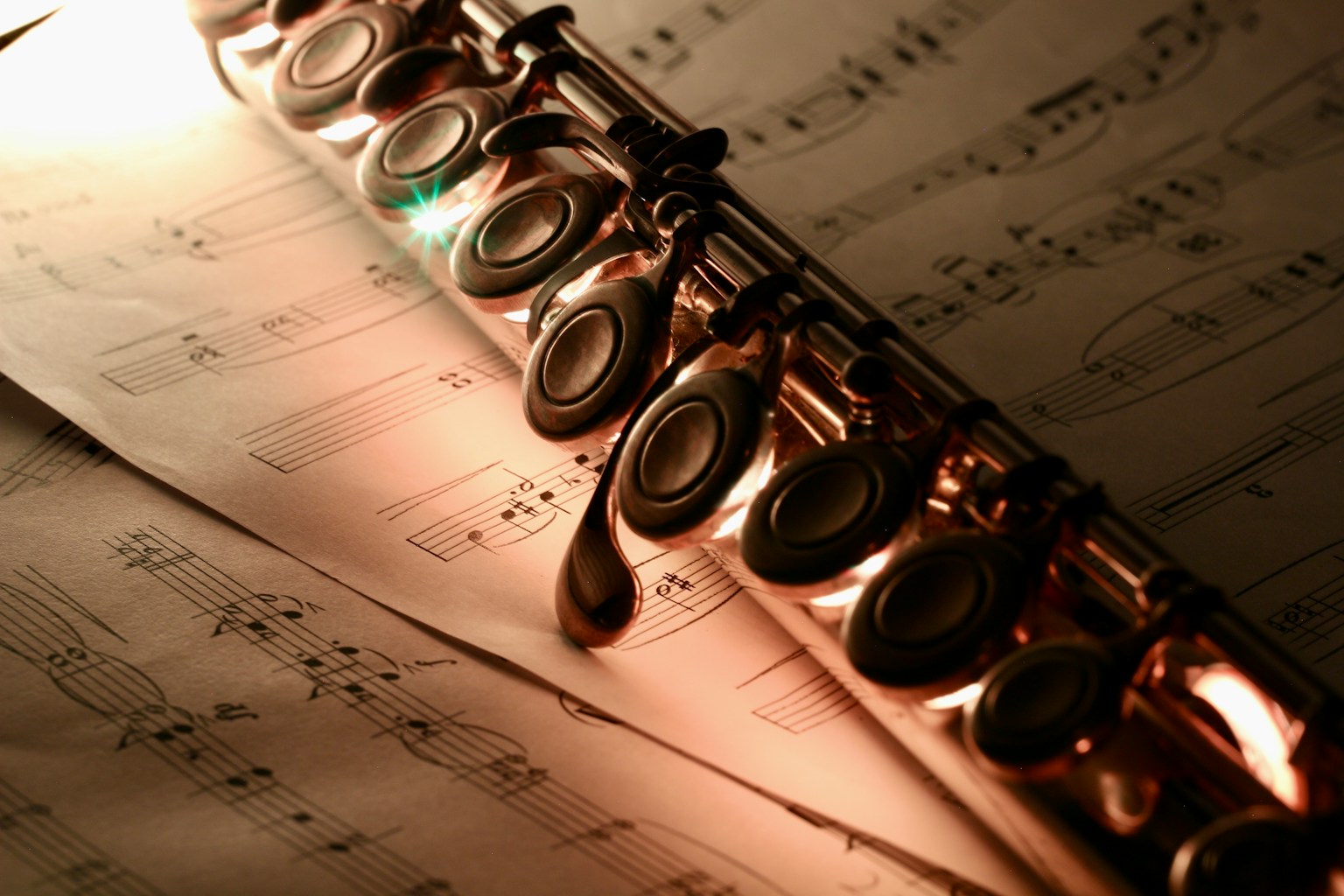 放在樂譜上的長笛特寫 長笛的金屬表面反射著光