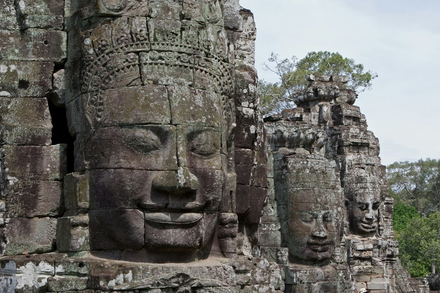 Gigantesche sculture di volti in pietra al tempio di Bayon ad Angkor Wat