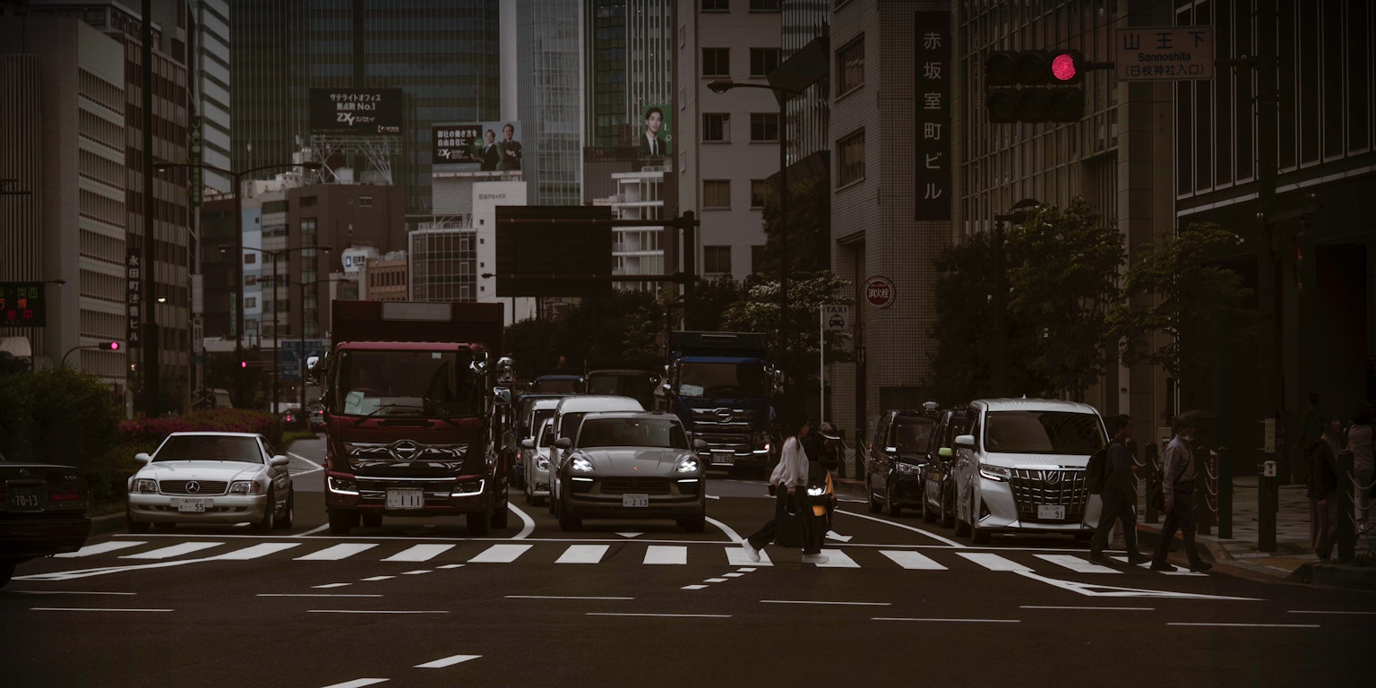 城市交叉口，車輛在移動，高樓和交通信號燈可見