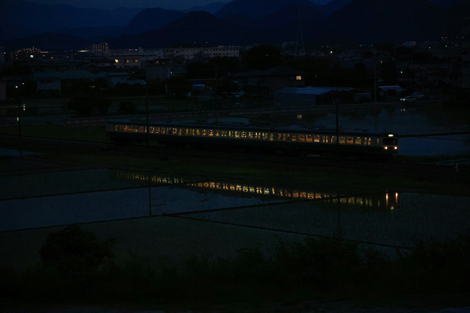 火車燈光在黑暗的鄉村景觀中反射