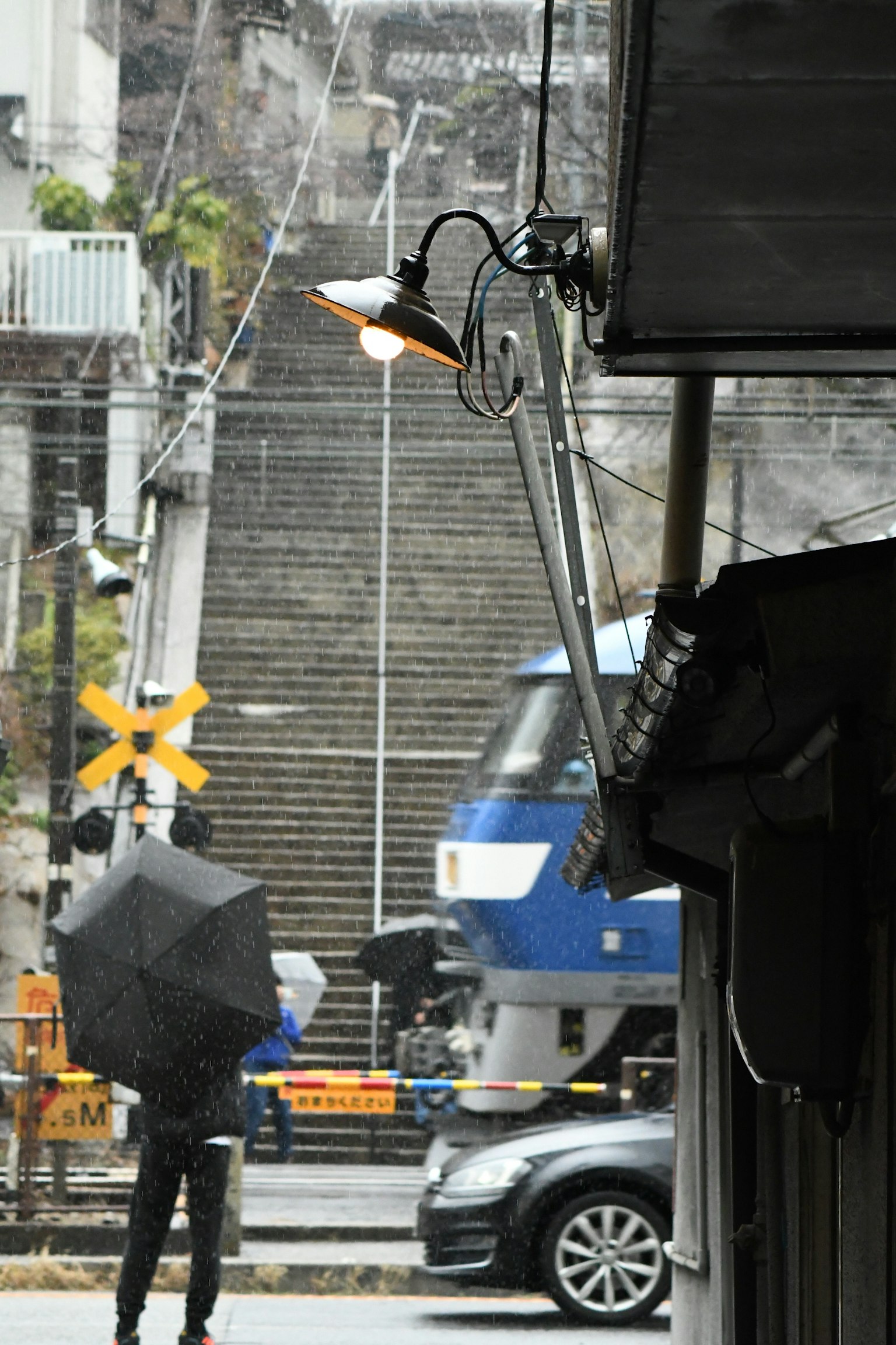 Une personne tenant un parapluie se tient près d'un escalier