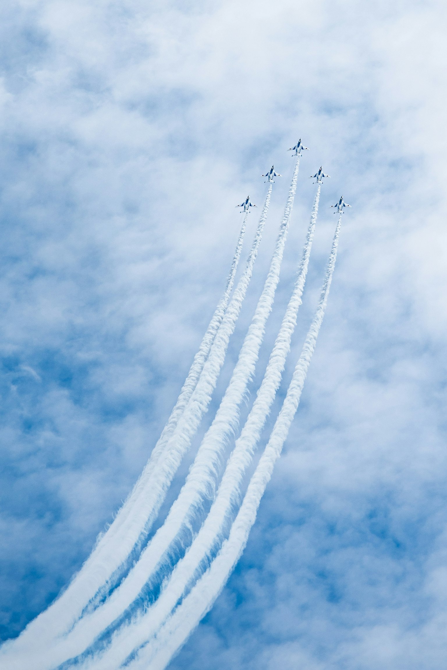 Aviones de combate creando estelas de humo en un cielo azul