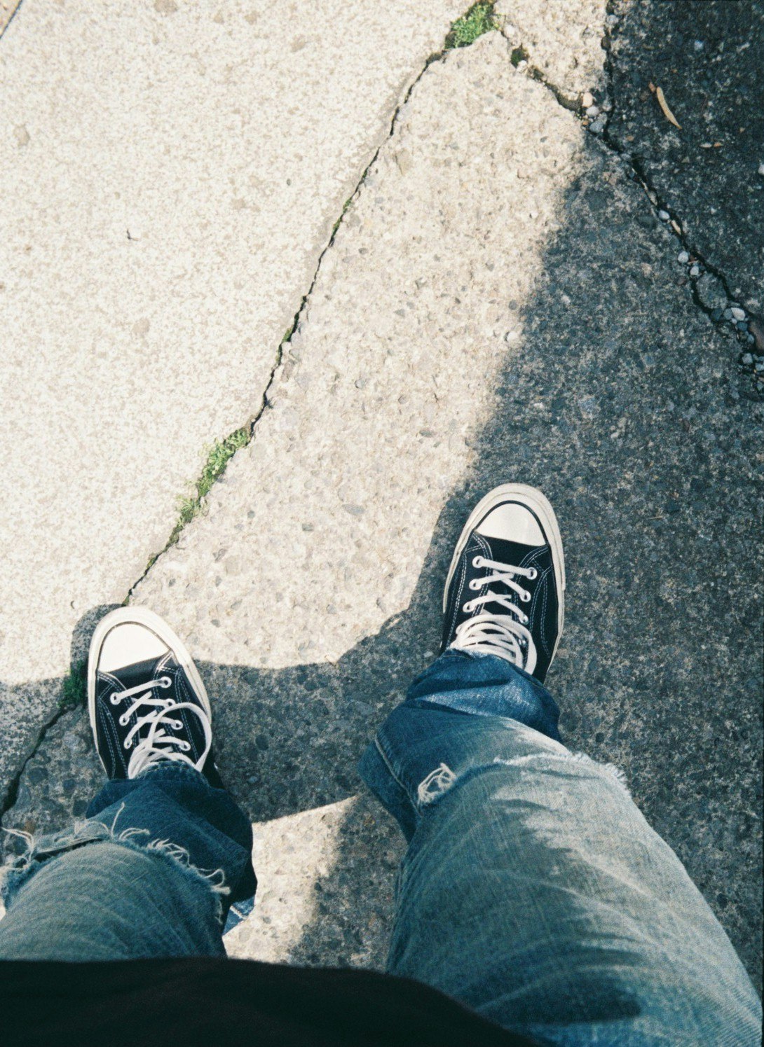 piedi con sneakers e jeans su gradini in cemento