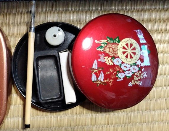set of a red fan-pattern case with a pen and brush