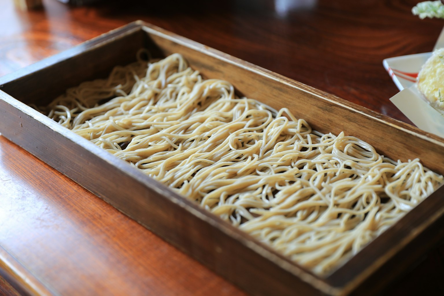 Ein Holztablett gefüllt mit Strängen von Soba-Nudeln