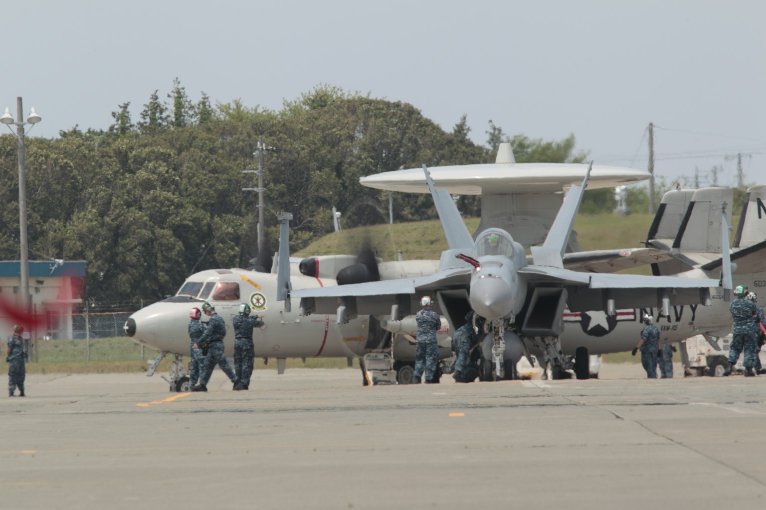 Nhân viên mặt đất làm việc quanh máy bay E-2C Hawkeye trên đường băng
