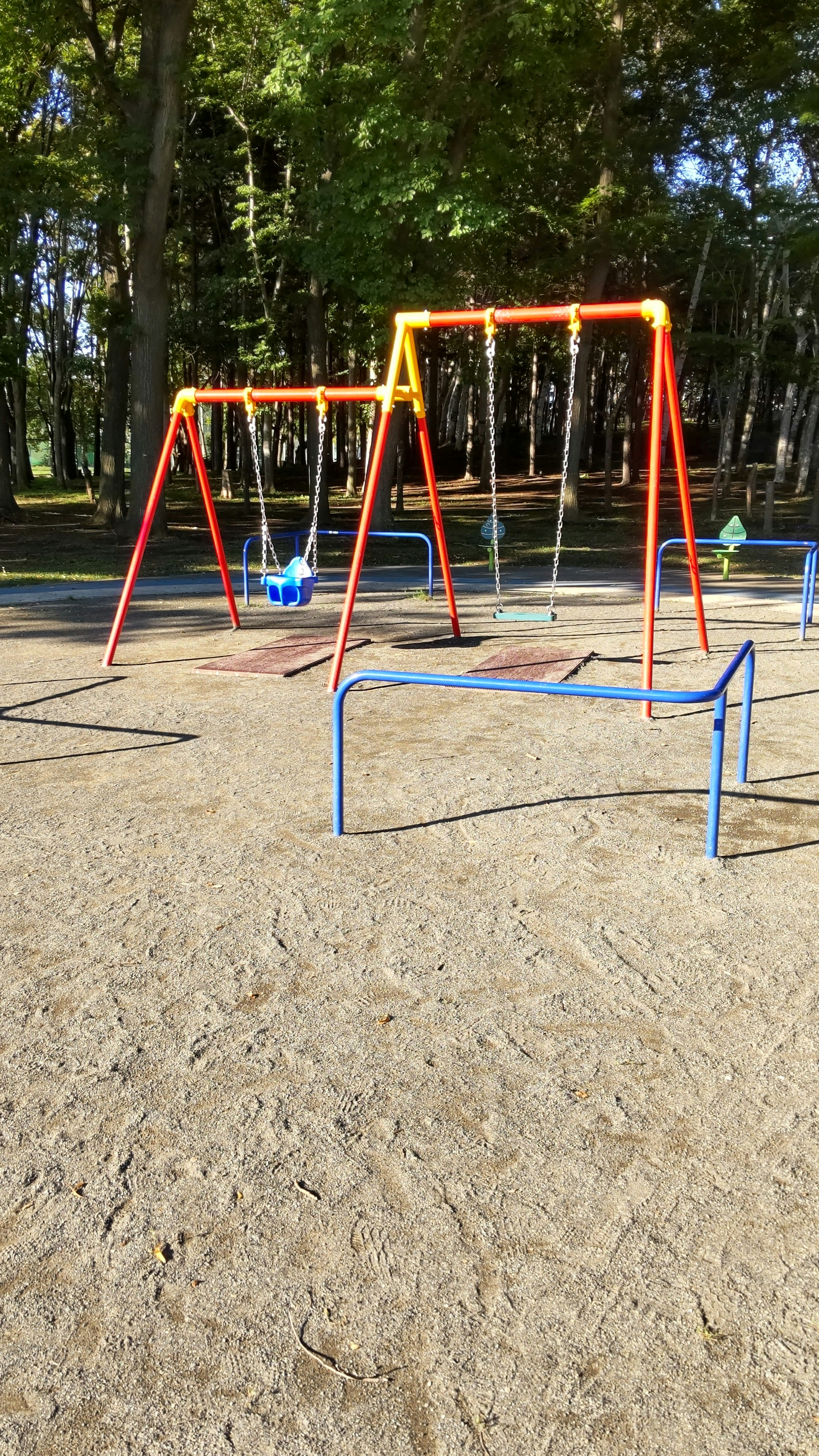 公園の遊具とカラフルな滑り台のある広場の風景