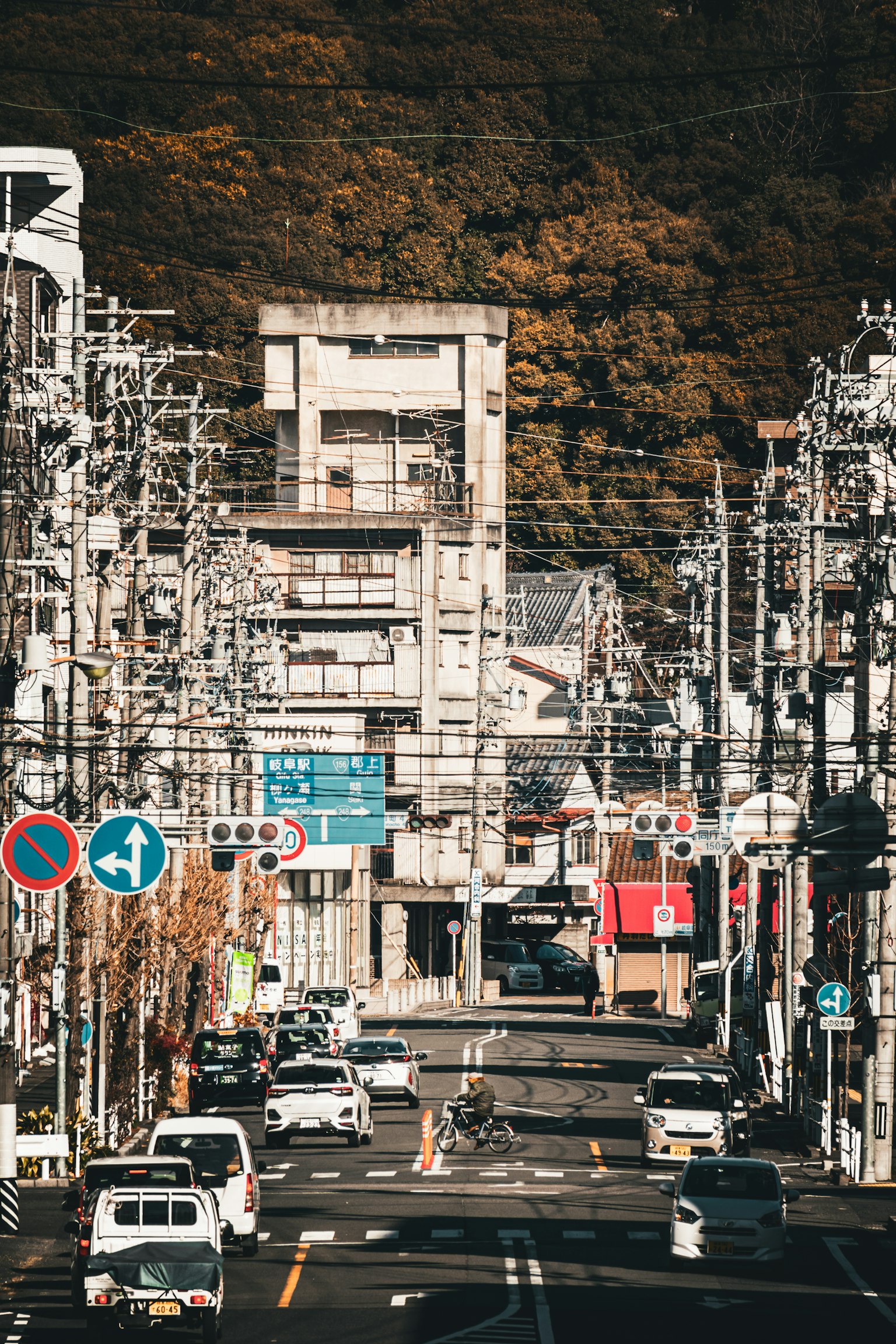 Urban street scene in Japan with autumn mountains in the background