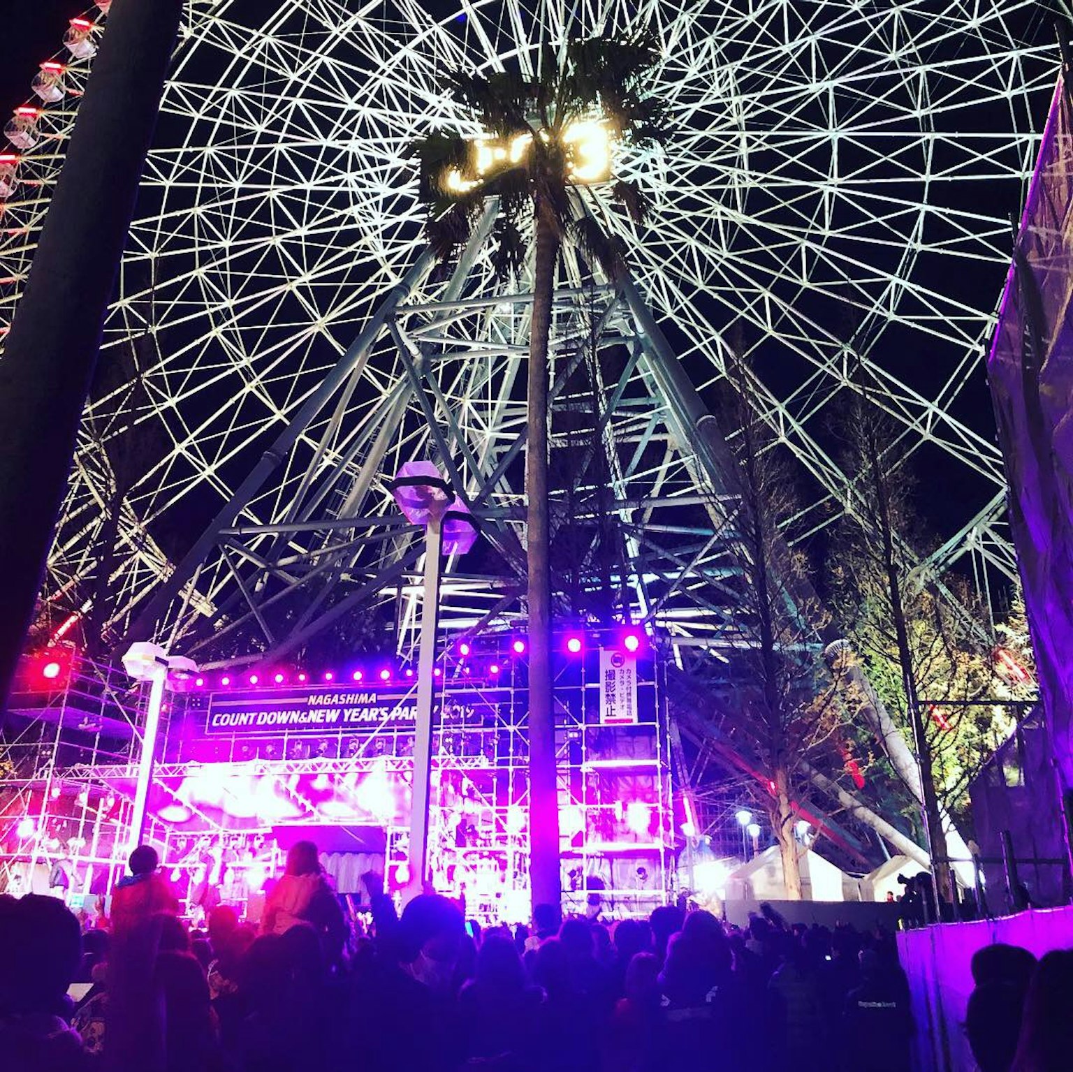 夜間熱鬧的活動場景，包含摩天輪和演出舞台