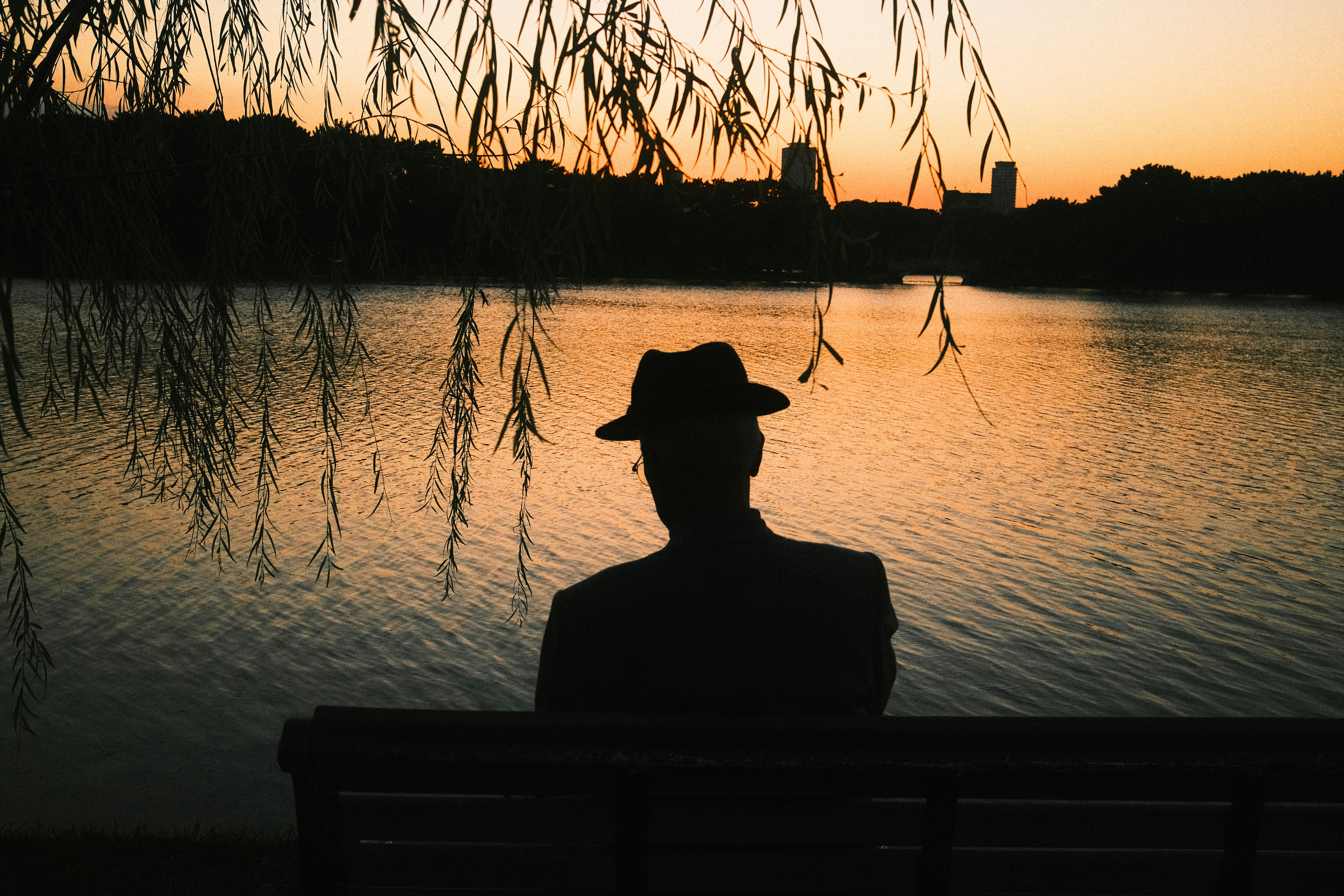 silhouette d’une personne au bord d’un lac au coucher du soleil