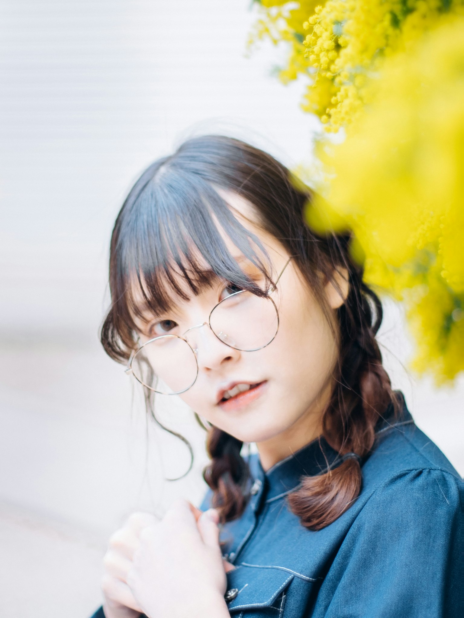 หญิงสาวใส่แว่นตาถ่ายรูปหน้าดอกไม้สีเหลือง