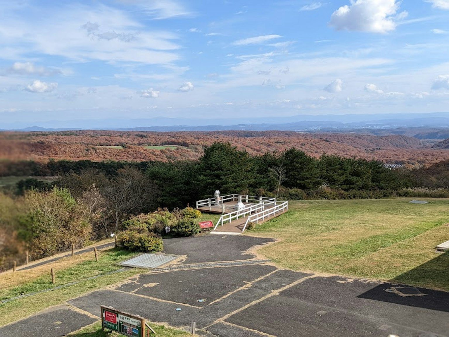 Vista panoramica con una terrazza di osservazione e erba verde sotto un cielo blu
