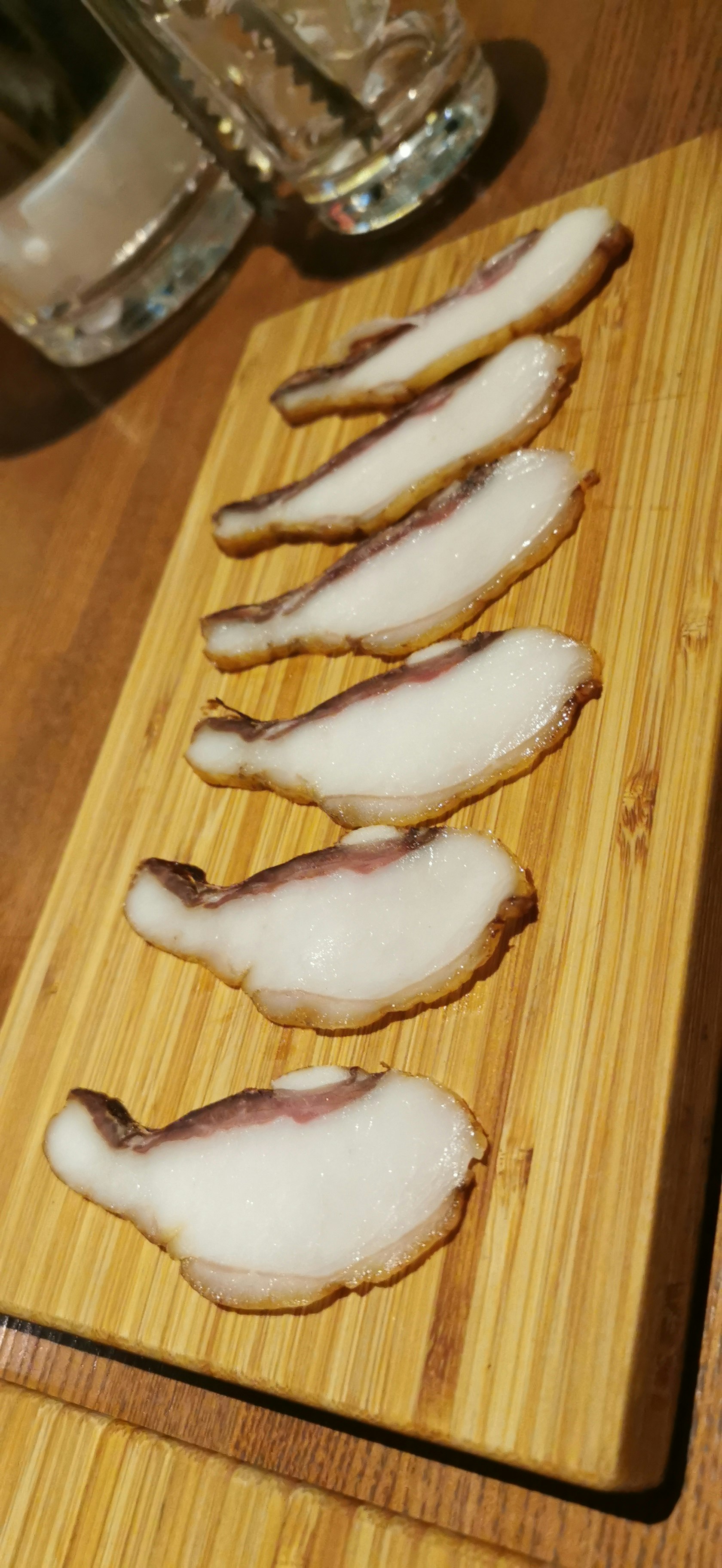 木製まな板に並ぶベーコンスライスの断面
