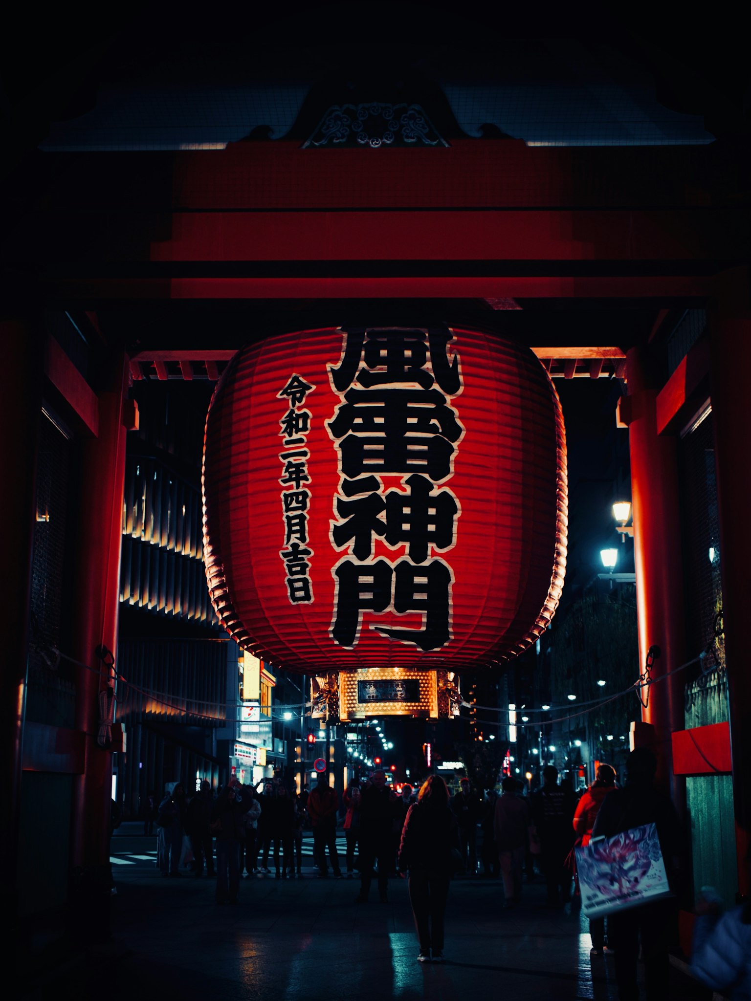 雷門の大きな提灯が夜に輝く風景 人々が通り過ぎる