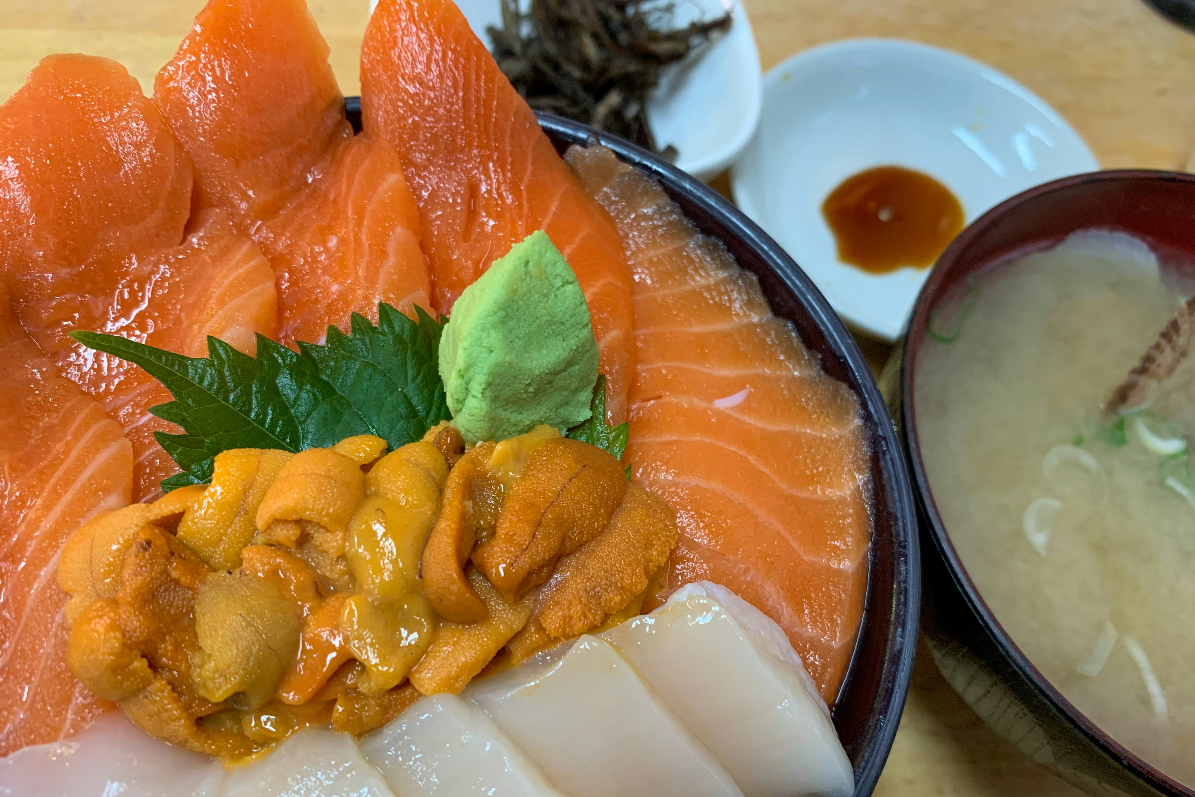 サーモンの刺身と薬味、味噌汁が並ぶ和食の定食